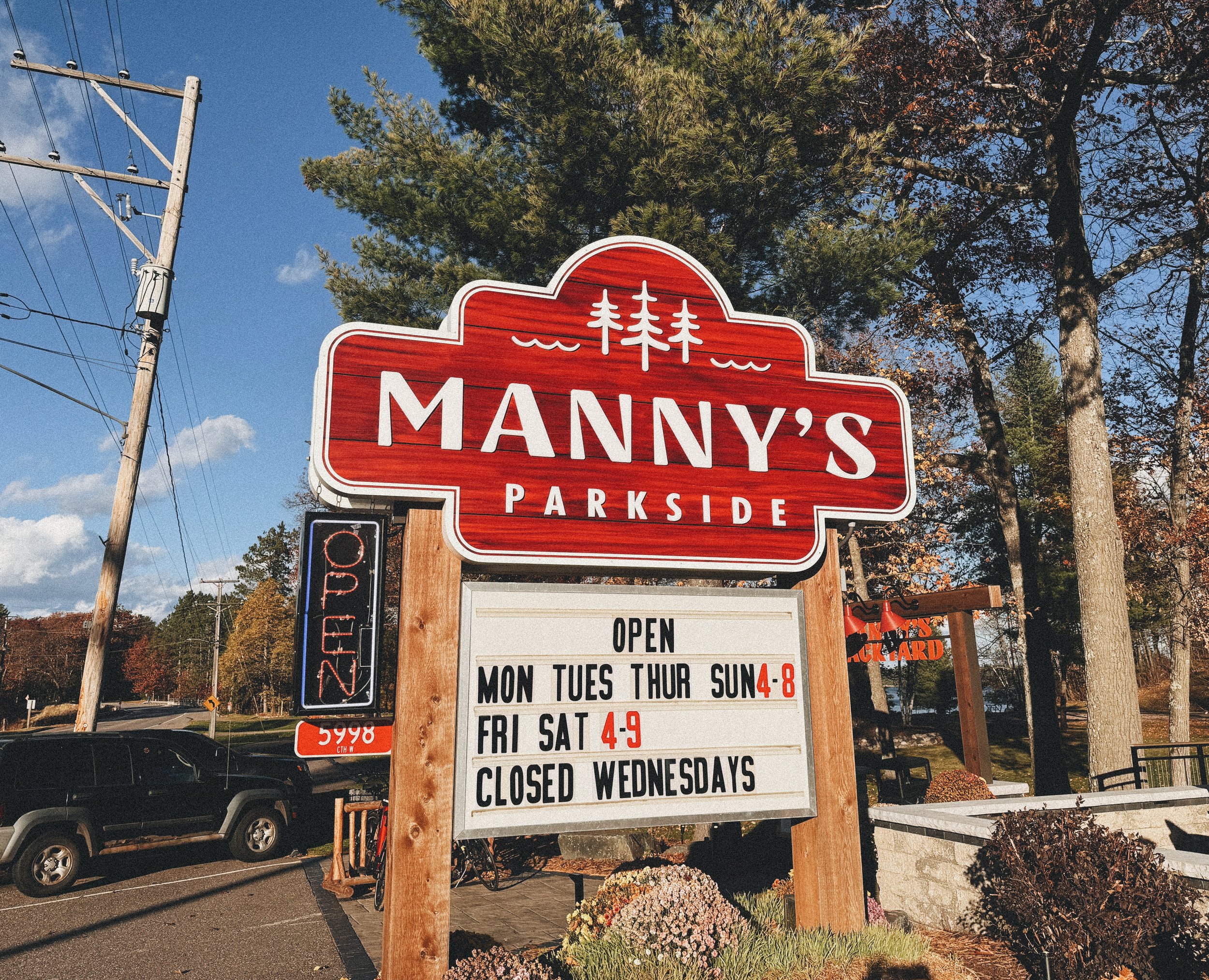 Manny’s Parkside sign on a sunny day, welcoming guests with vibrant weather and inviting atmosphere.