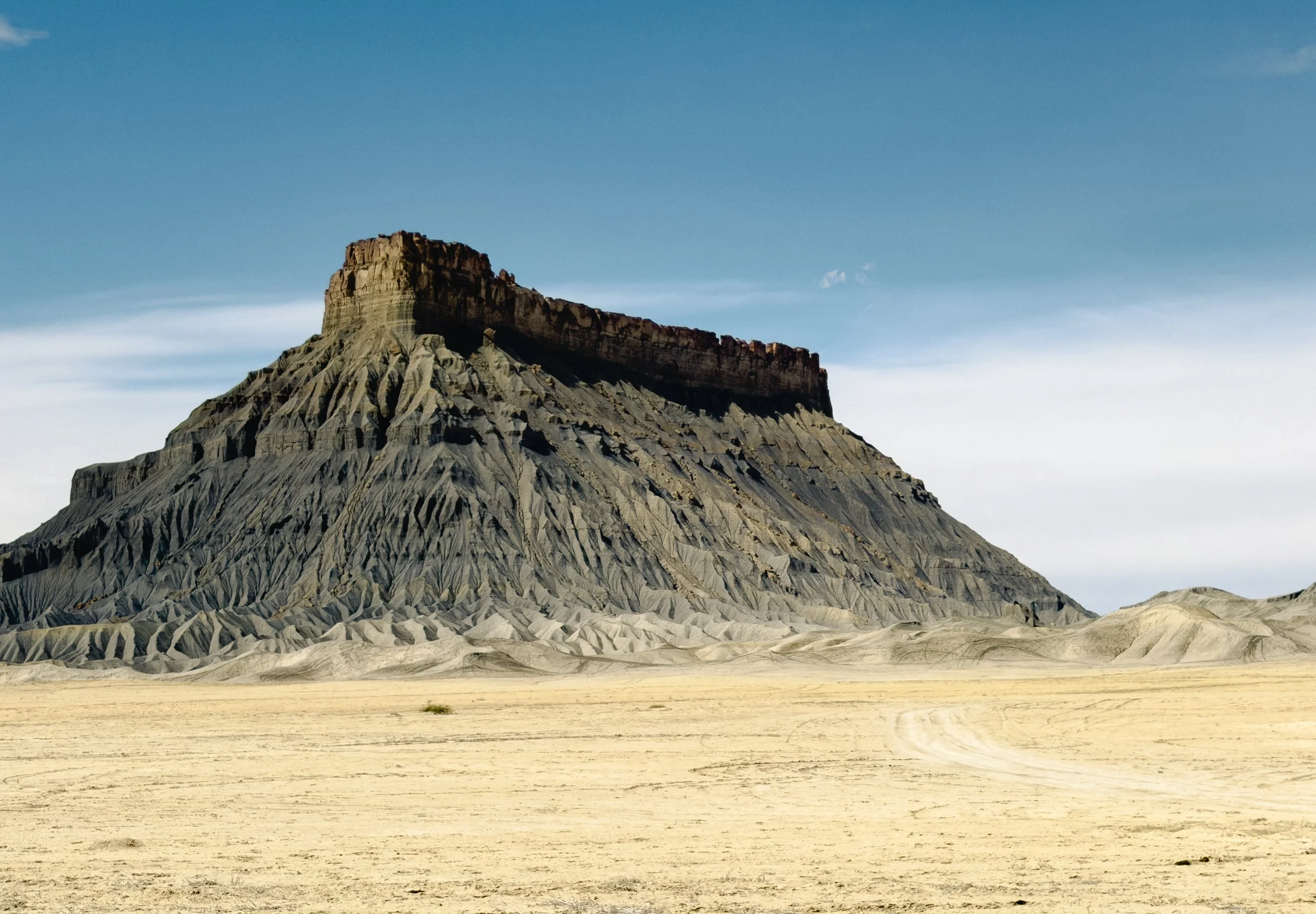 Factory Butte in central Utah with flat-topped butte formation rising above desert badlands