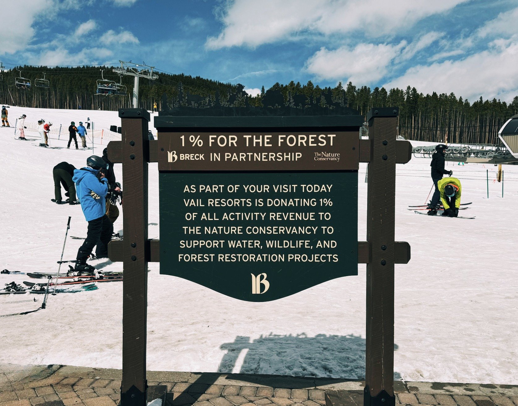 Sign at the base of Peak 8 at Breckenridge Ski Resort, showcasing the resort's 1% donation to The Nature Conservancy for environmental conservation.