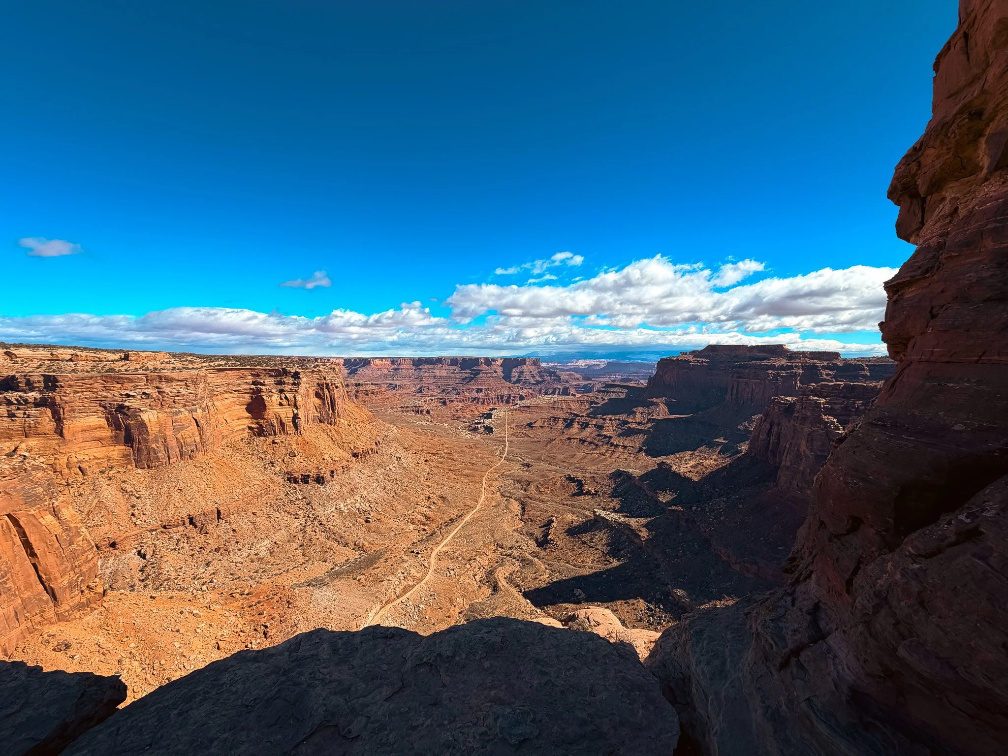 View from Shafer Canyon Overlook in Canyonlands National Park looking down into the canyon with the Shafer Trail visible below.