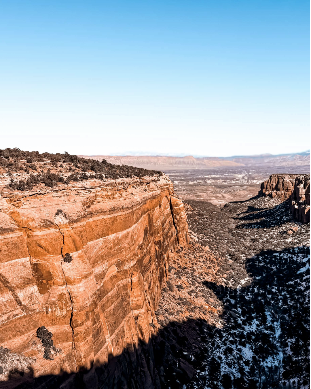 Sheer canyon cliffs and desert landscape at Colorado National Monument viewed from Rim Rock Drive
