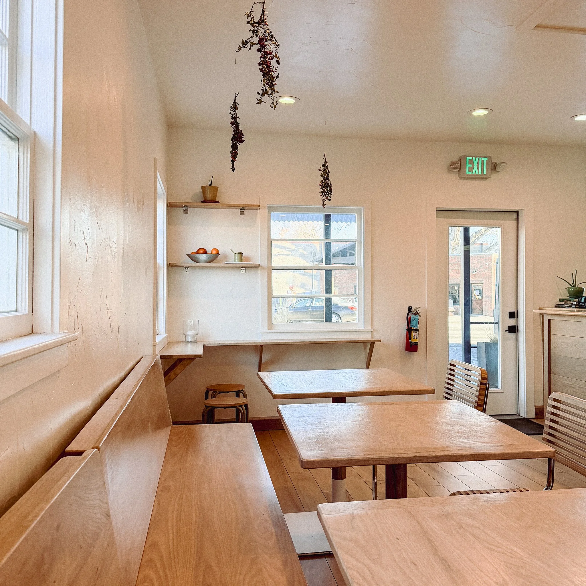 Interior of Cafe Fritz in Hygiene, Colorado with wooden tables, benches, and dried herbs hanging from the ceiling.