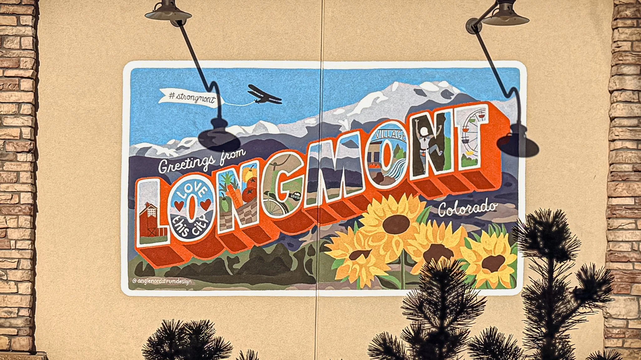 Colorful Greetings from Longmont mural painted on a building in downtown Longmont, Colorado.