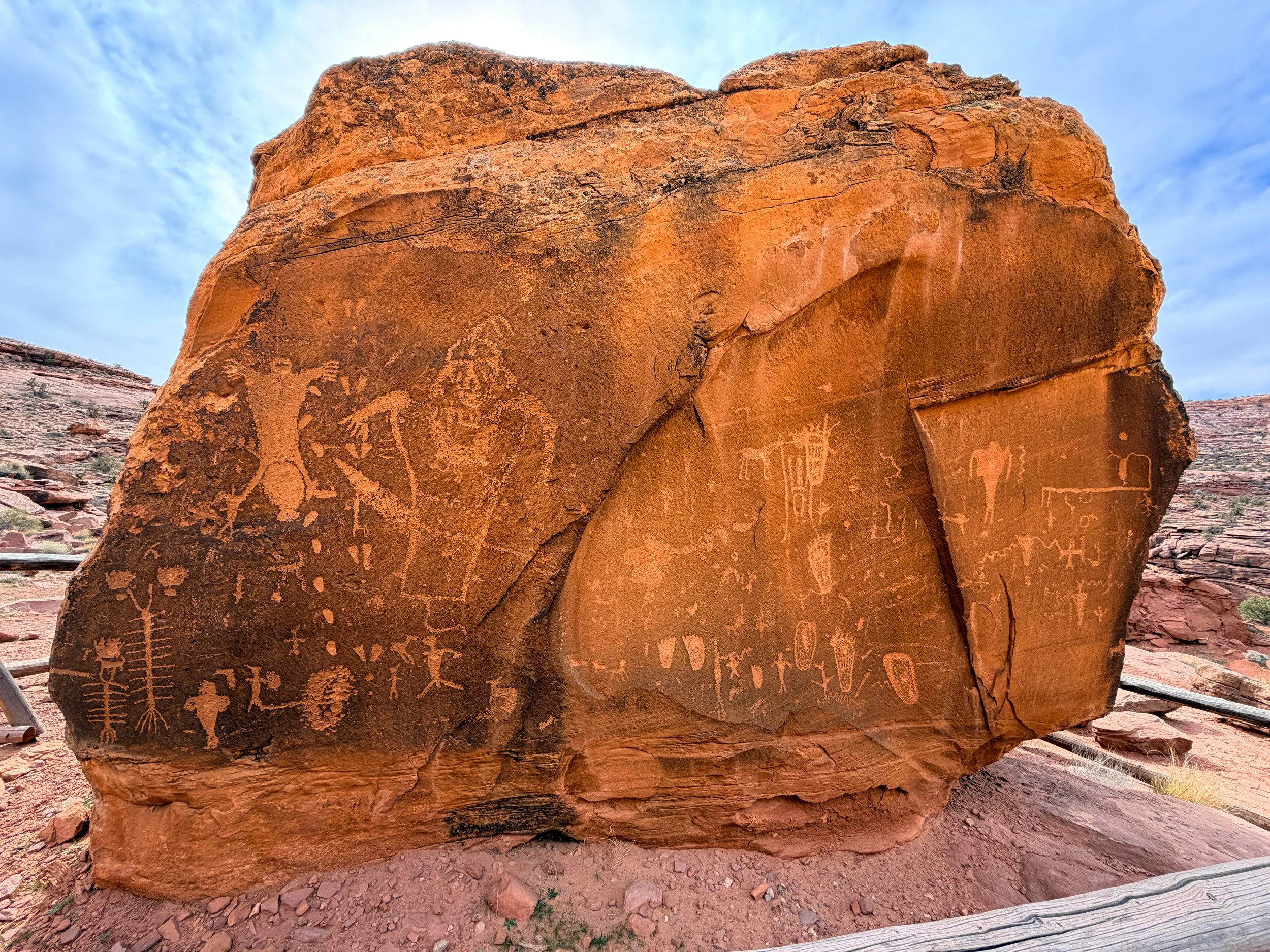 Birthing Scene petroglyph panel on a large sandstone boulder along Potash Road near Moab, Utah, showing Fremont anthropomorphic figures carved through desert varnish.