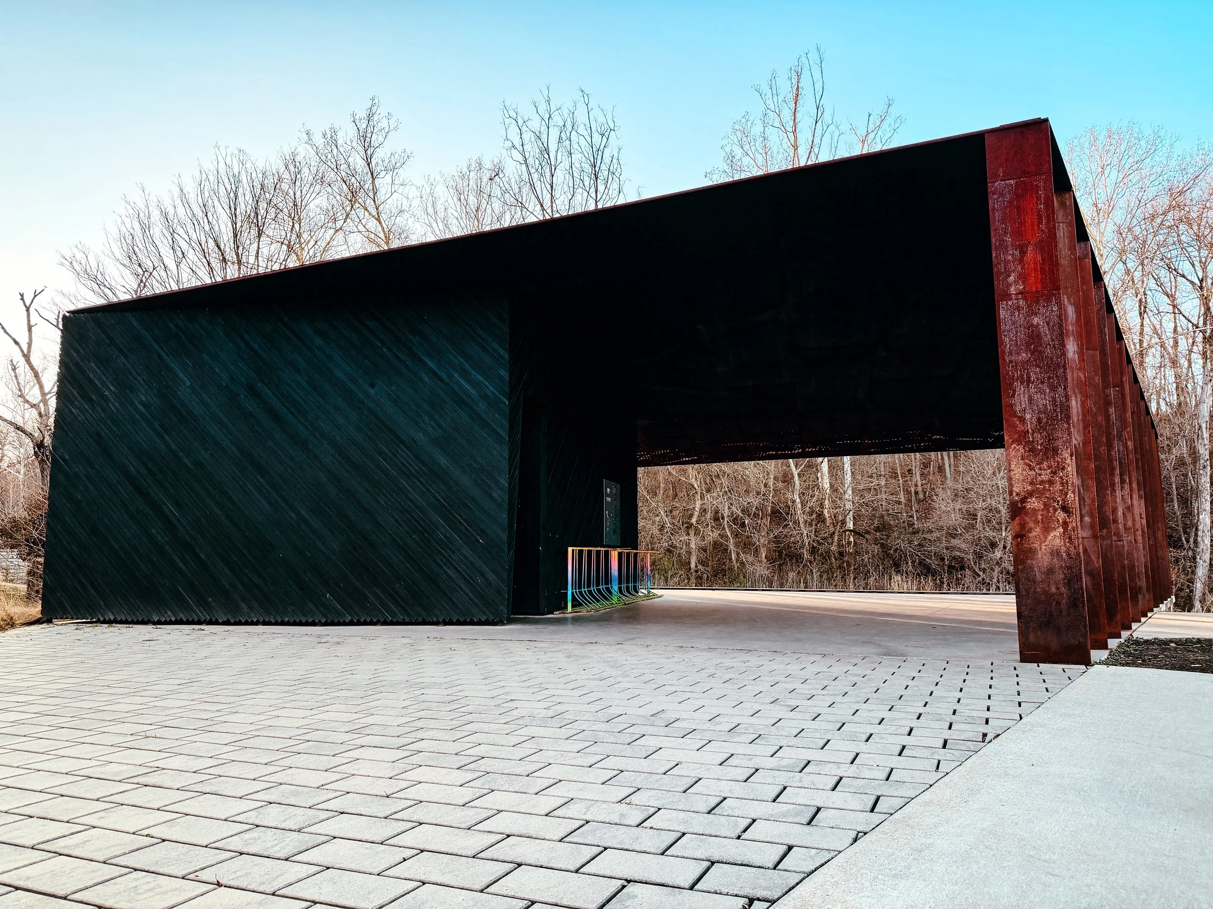 Modern covered structure made of weathered steel and dark wood at Coler Mountain Bike Preserve.