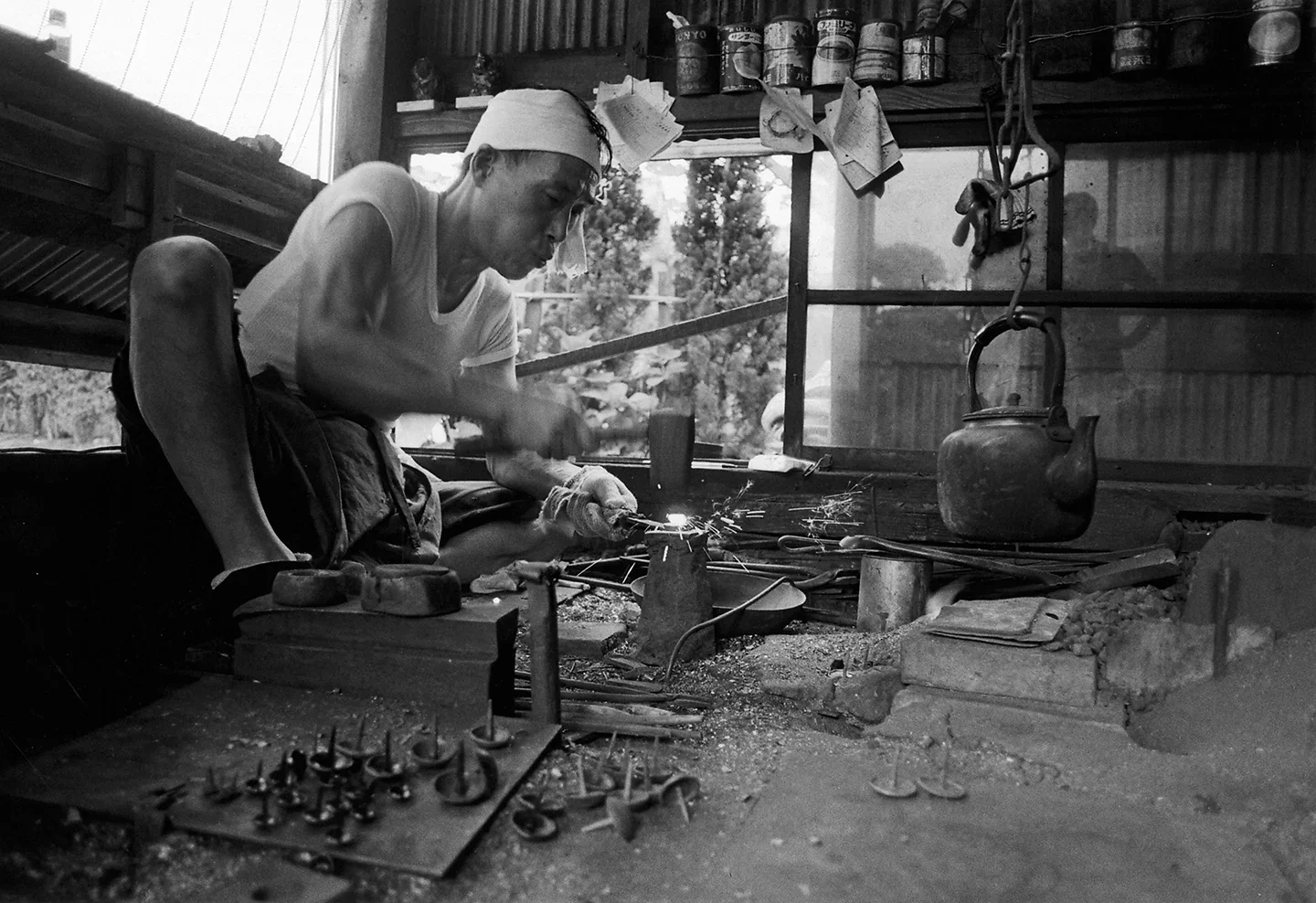 Japanese craftsman metalworking by hand in workshop showing traditional fabrication techniques