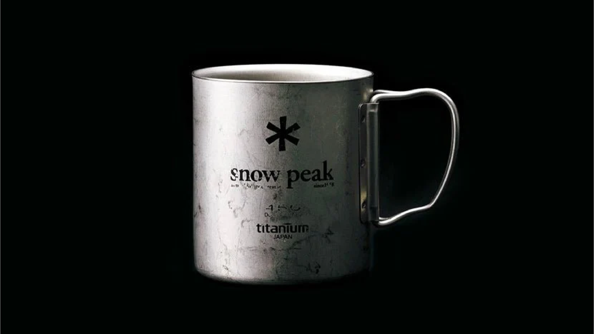 Snow Peak titanium cup in classic silver photographed on a black background, showing the lightweight single-wall titanium design.