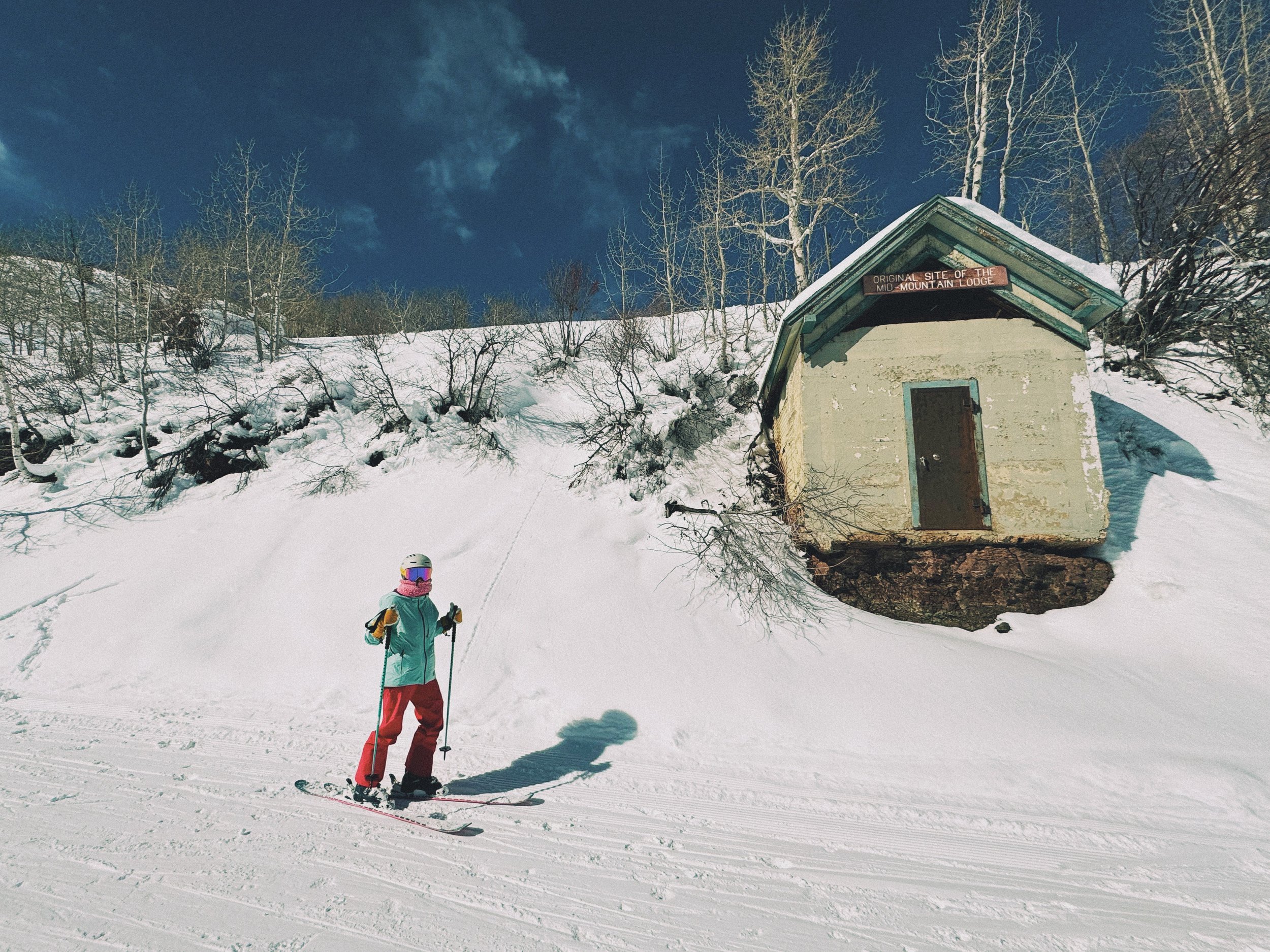 Kelly posing by one of the many historic mining artifacts along Homerun on the Park City side, blending skiing with a touch of history.