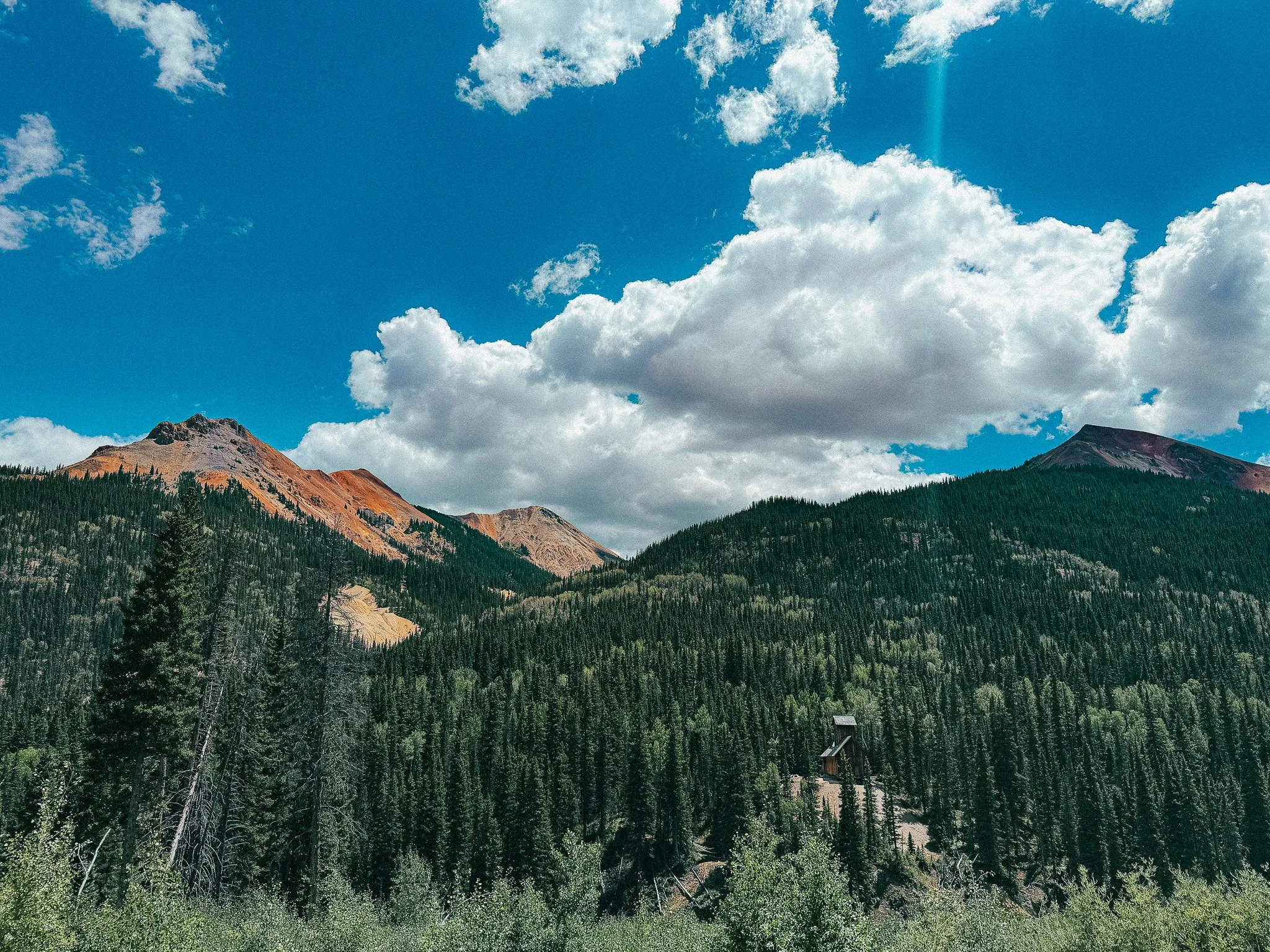 Old mining structure surrounded by forest below Red Mountain along the Million Dollar Highway in Colorado.