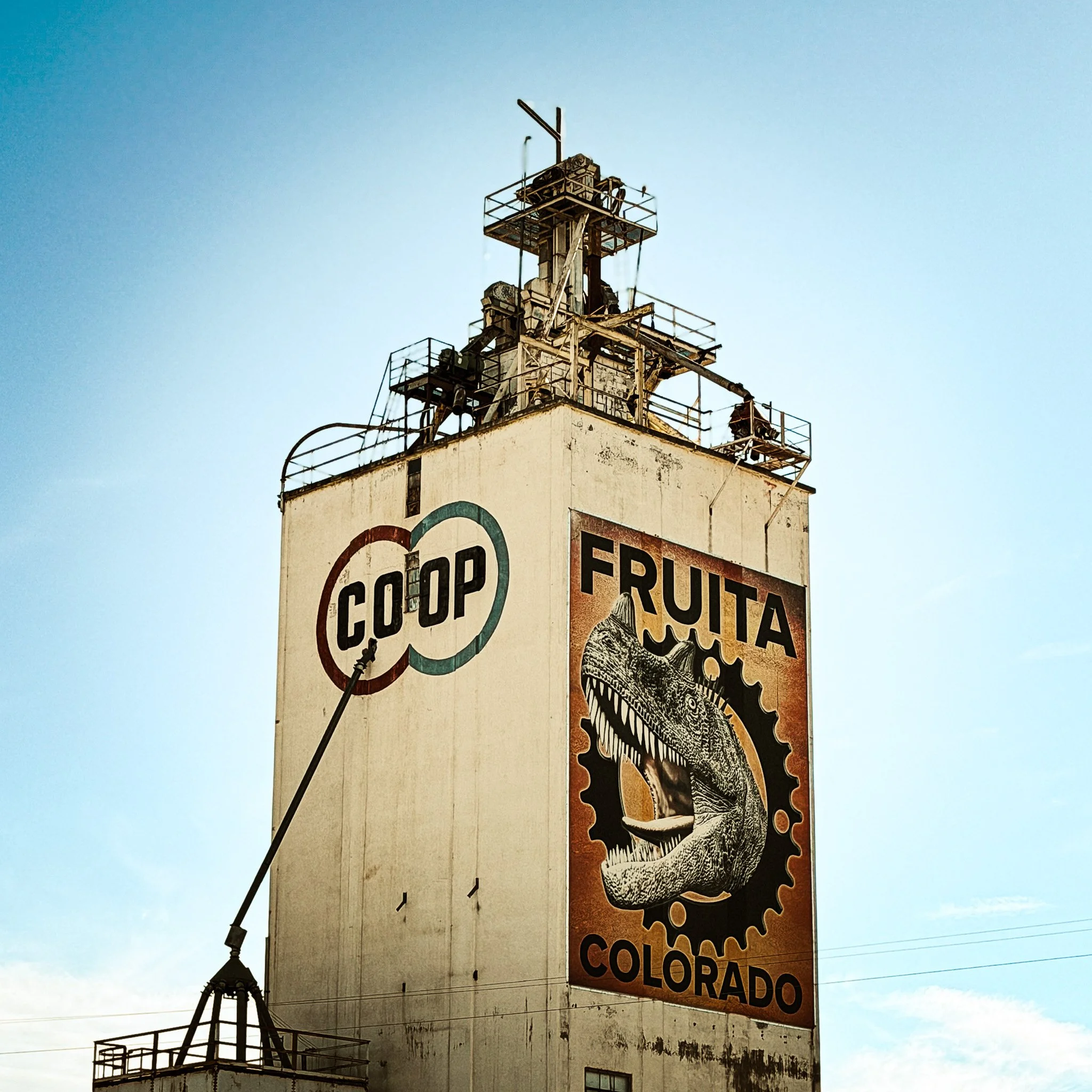 Grain elevator in Fruita painted with a large dinosaur mural and the word Colorado.