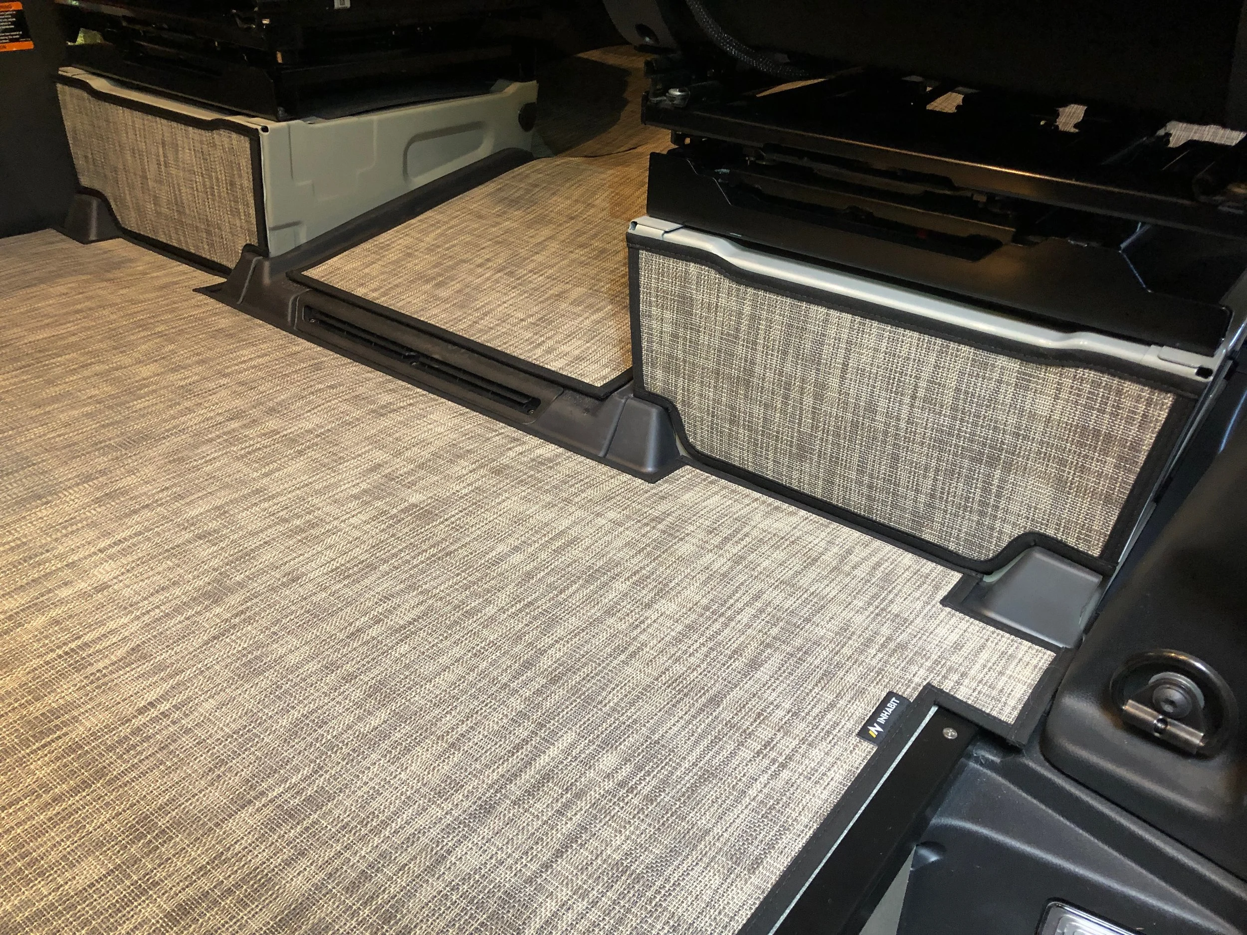 Inhabit Mats seat box cover installed in van showing fabric texture and fit