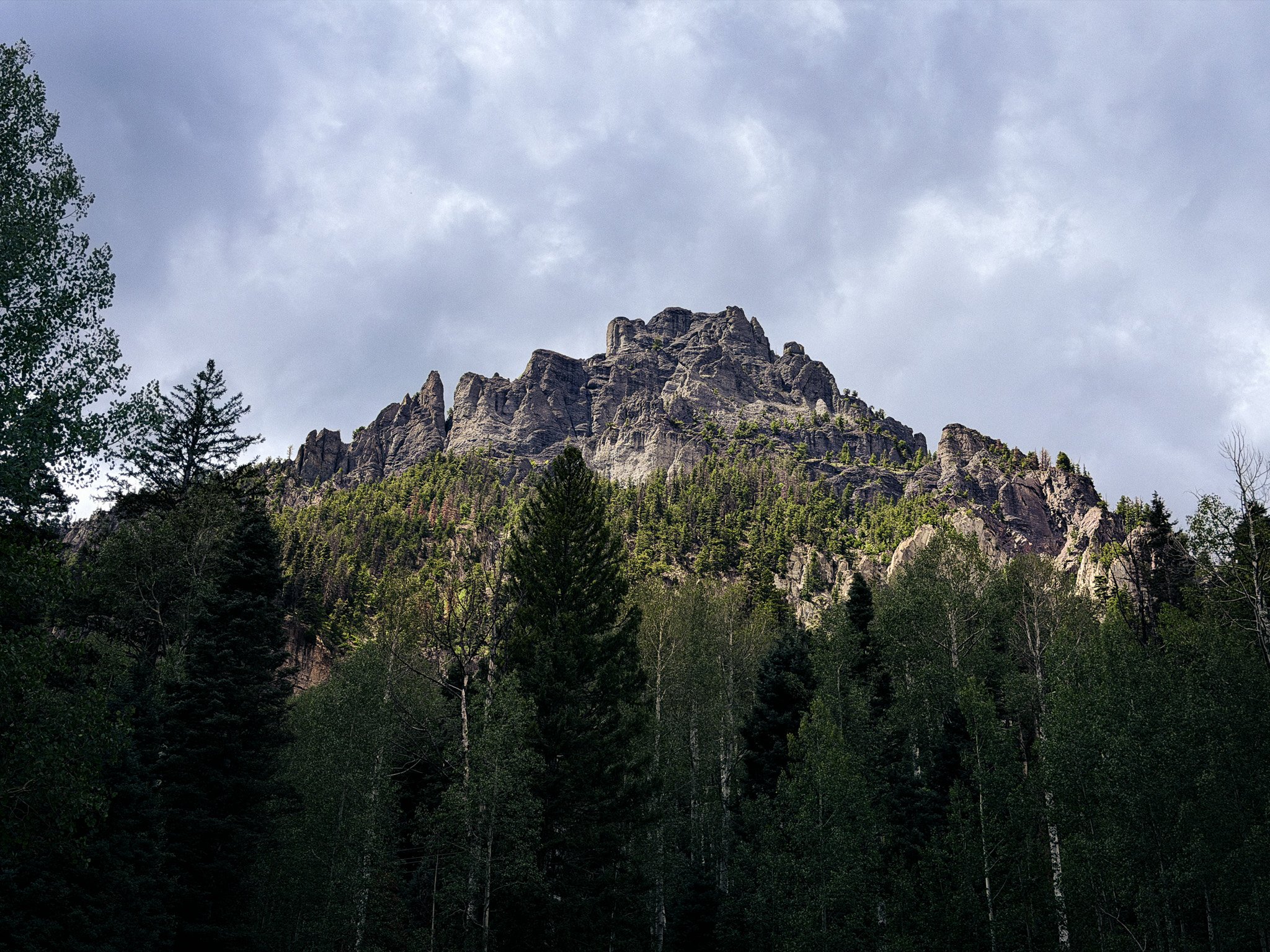Rugged rock formation rising above the forest in Colorado's San Juan Mountains