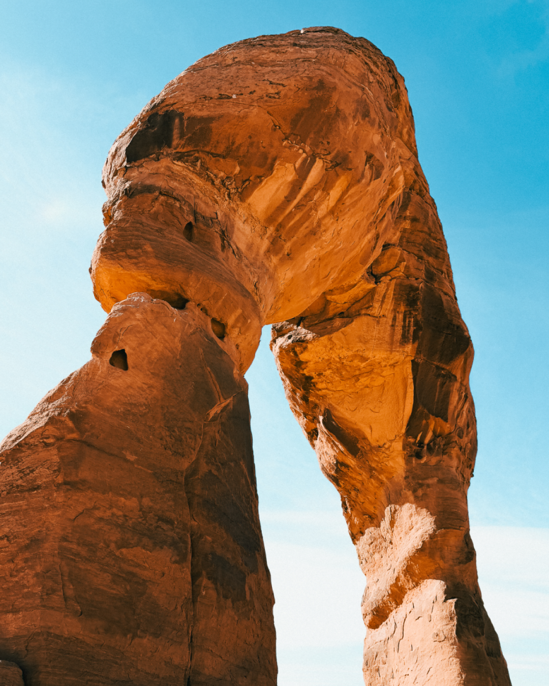 Close-up view of Delicate Arch sandstone texture and shape against blue sky in Utah