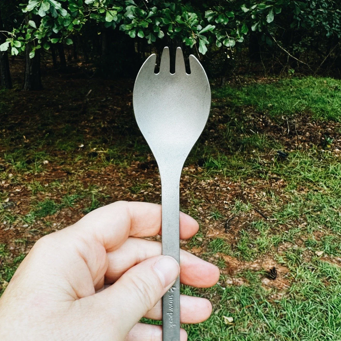 Snow Peak titanium spork held in hand outdoors camping van life