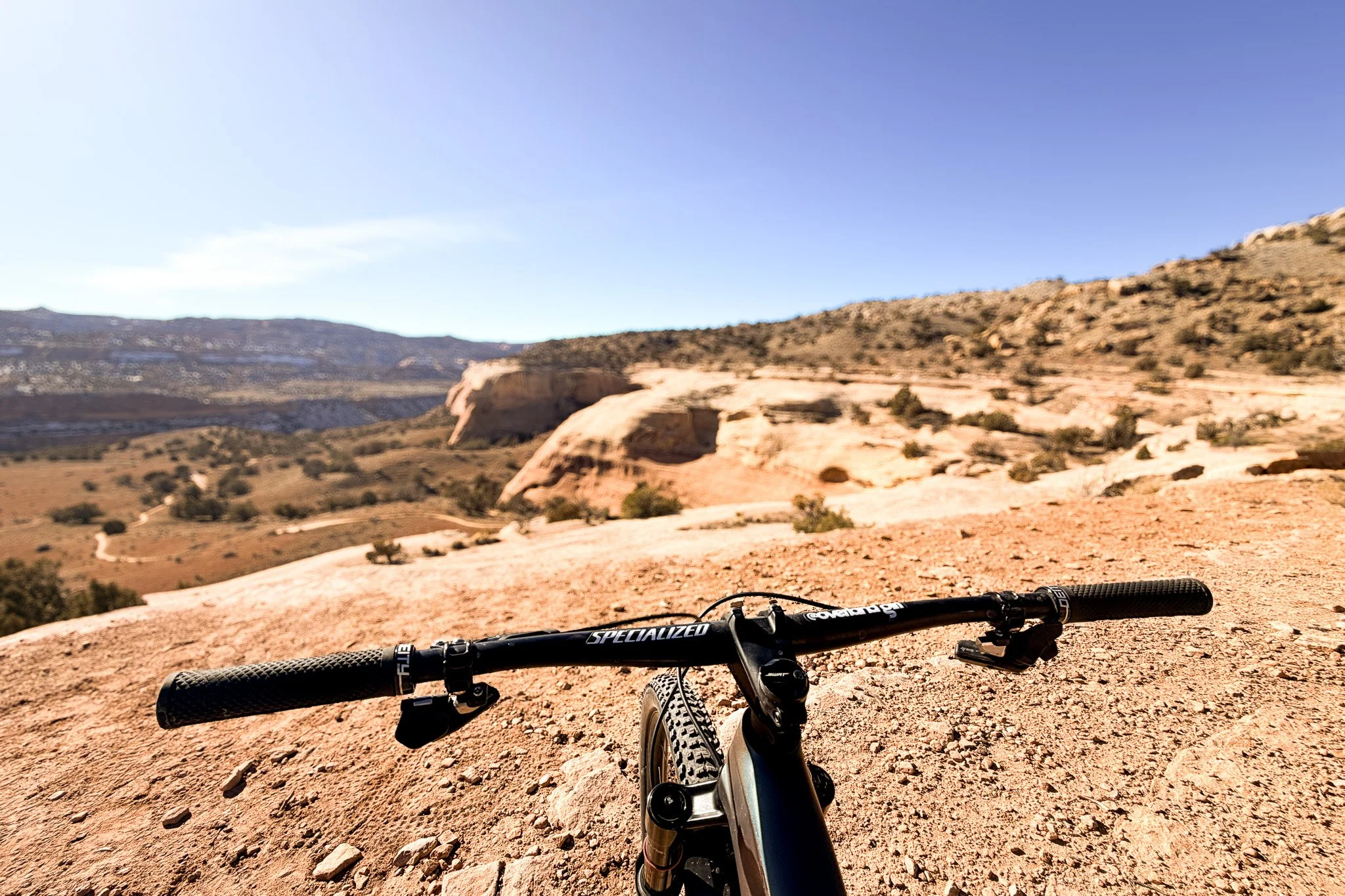 Mountain bike handlebars overlooking desert slickrock and canyon terrain on Mary’s Trail in the Kokopelli Trails near Fruita, Colorado.