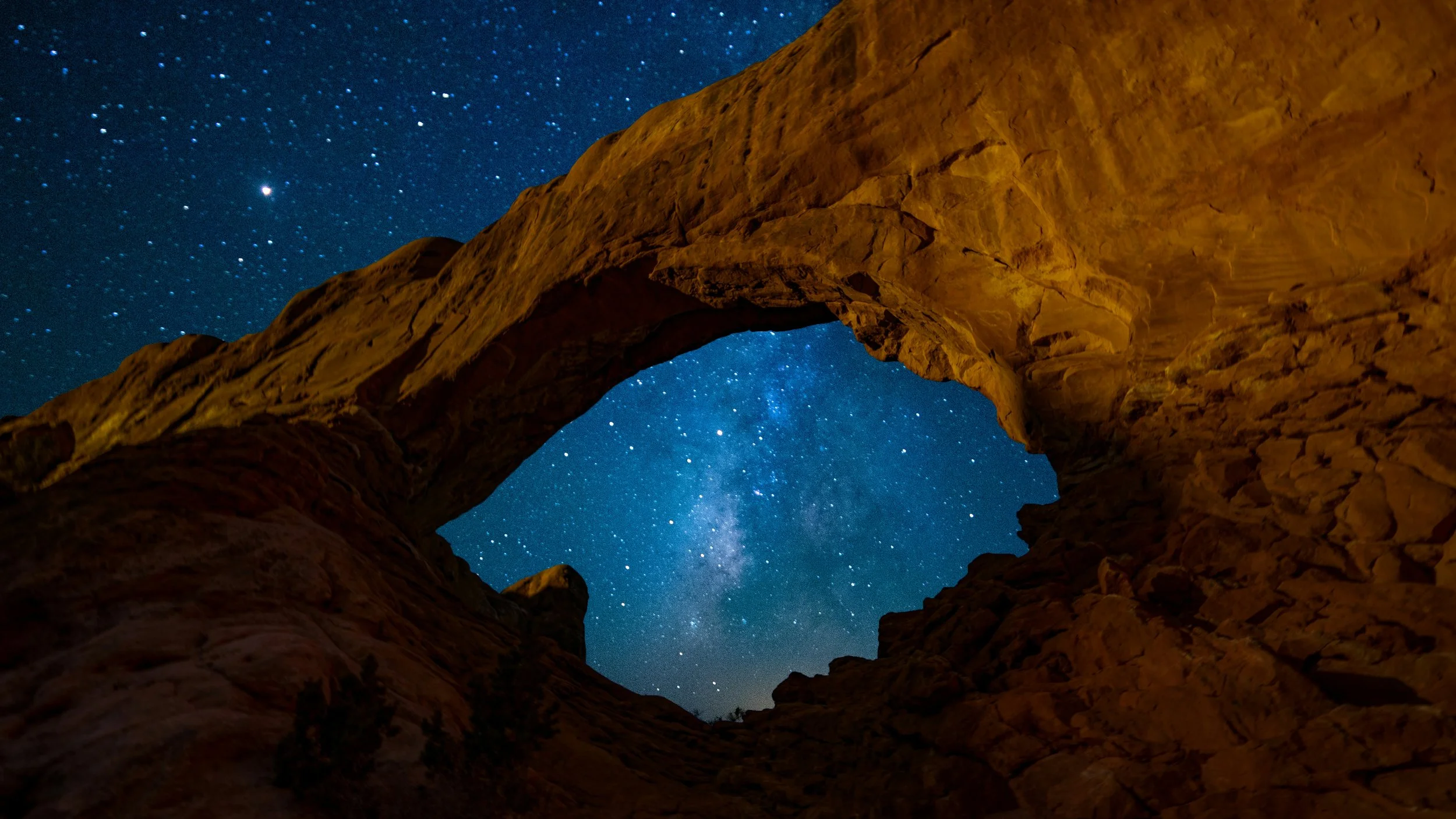 Milky Way framed by sandstone arch in Arches National Park Utah dark sky