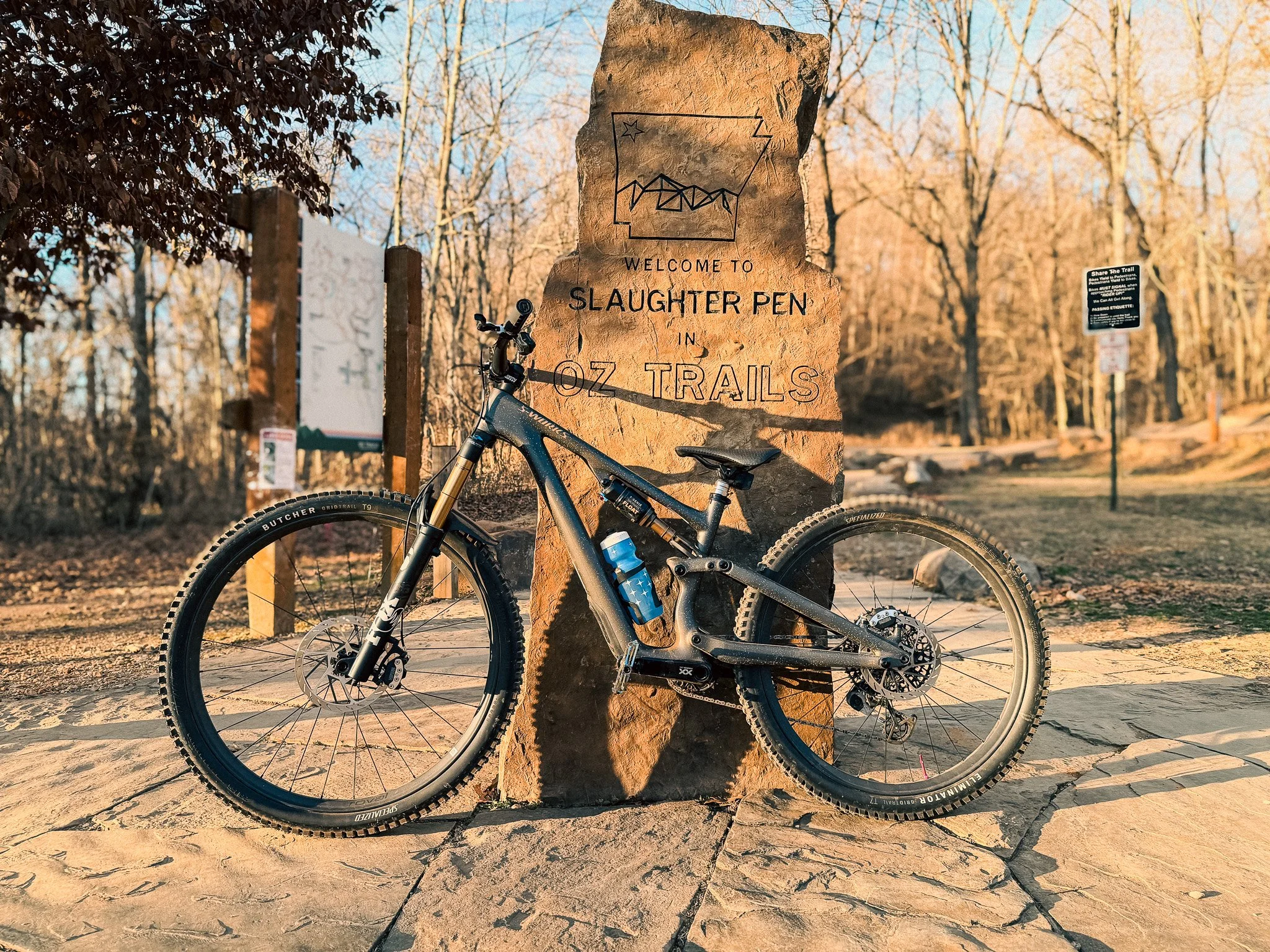 S-Works Epic EVO Pro mountain bike leaned against the Slaughter Pen Phase 3 trail marker in Bentonville, Arkansas.