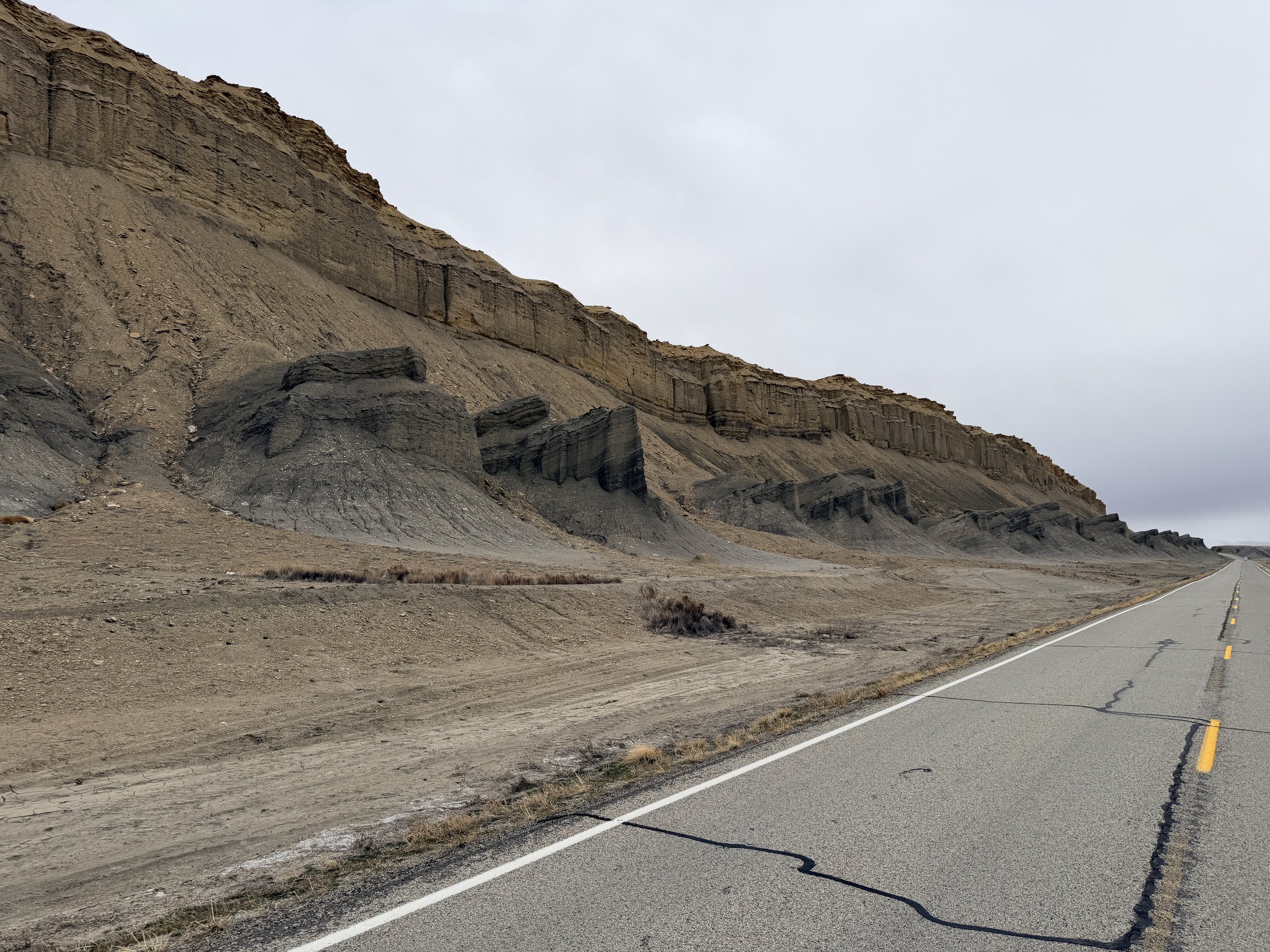 Remote highway through grey desert landscape in southern Utah