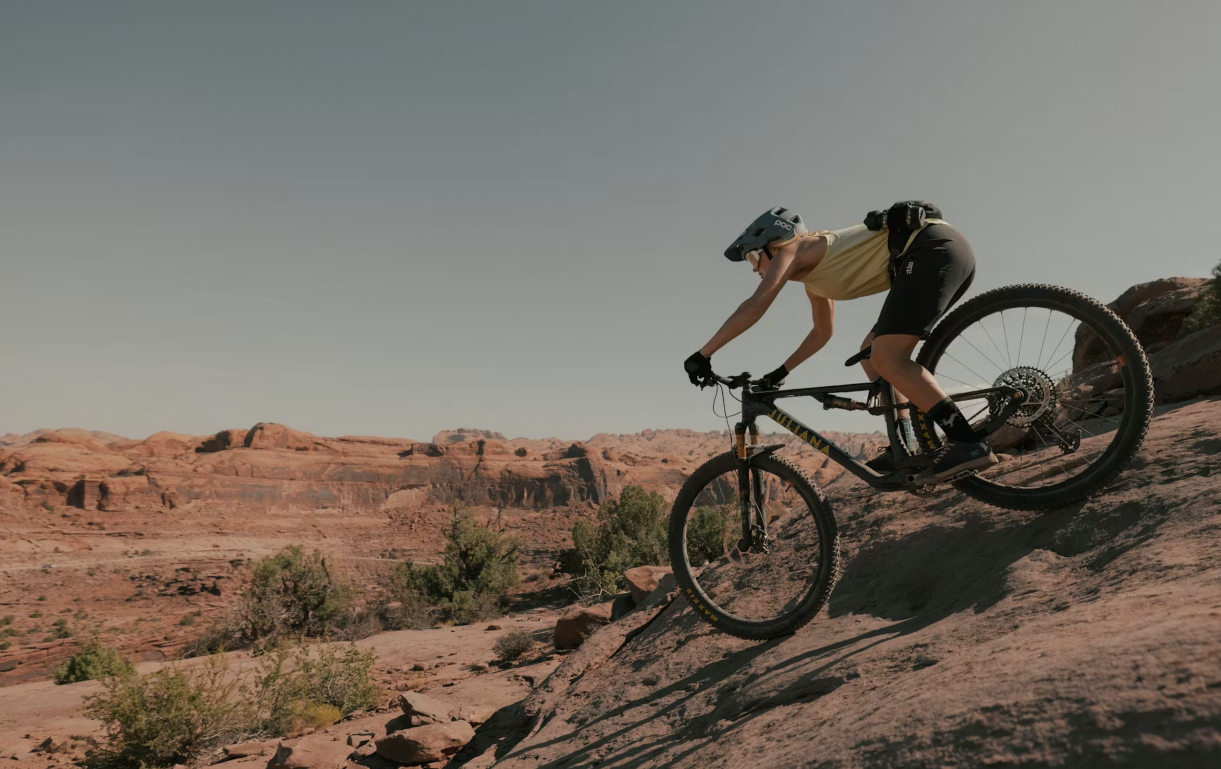 Woman mountain biking on slickrock terrain in Moab wearing Stio Women’s OPR Shorts