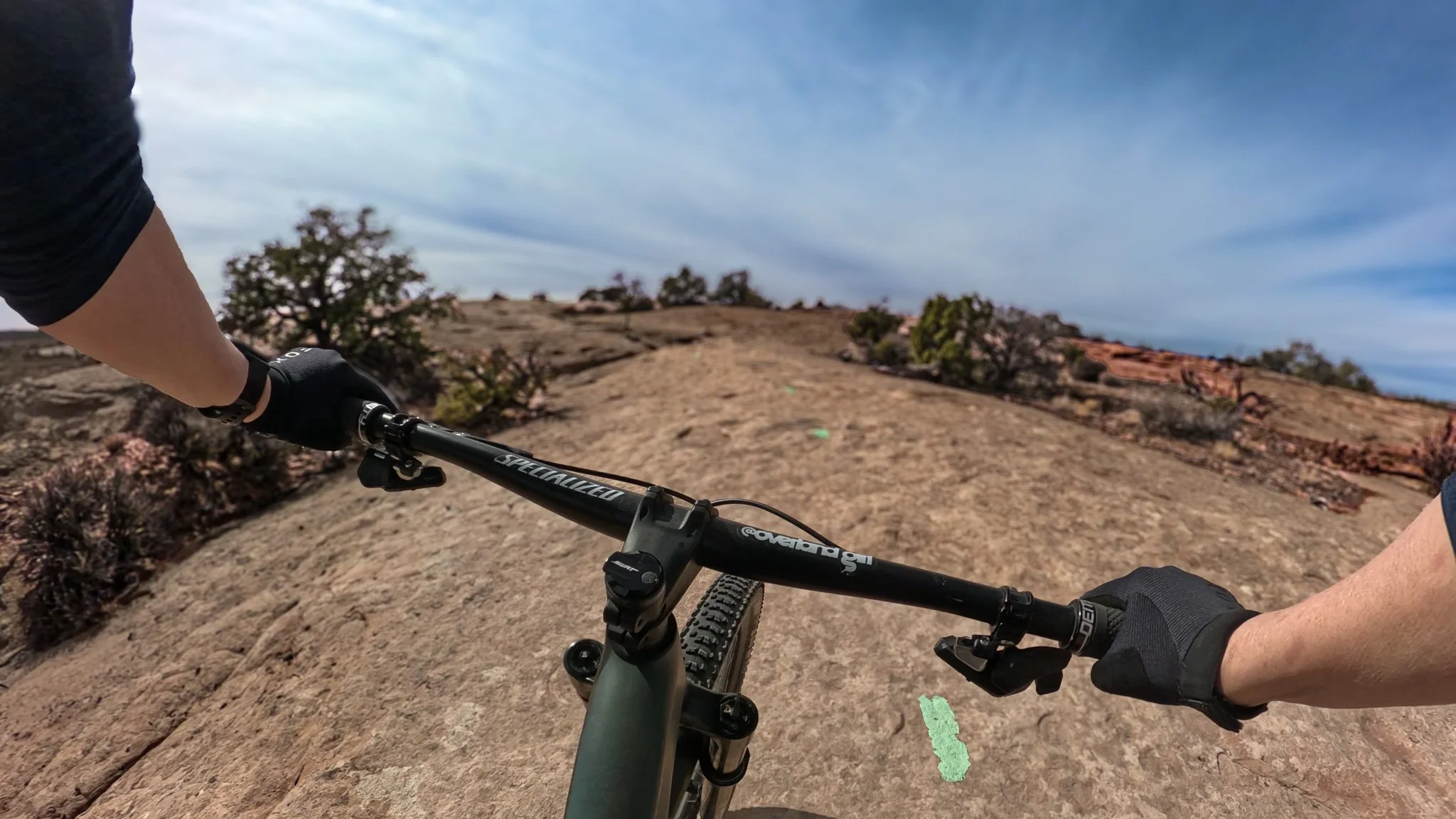 Mountain biking across slickrock on the Big Lonely trail in the Navajo Rocks system near Moab, Utah.