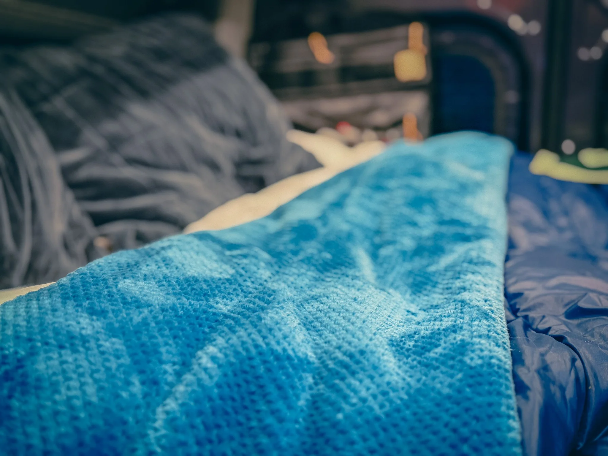 Rumpl blanket layered on camper van bed for van life camping