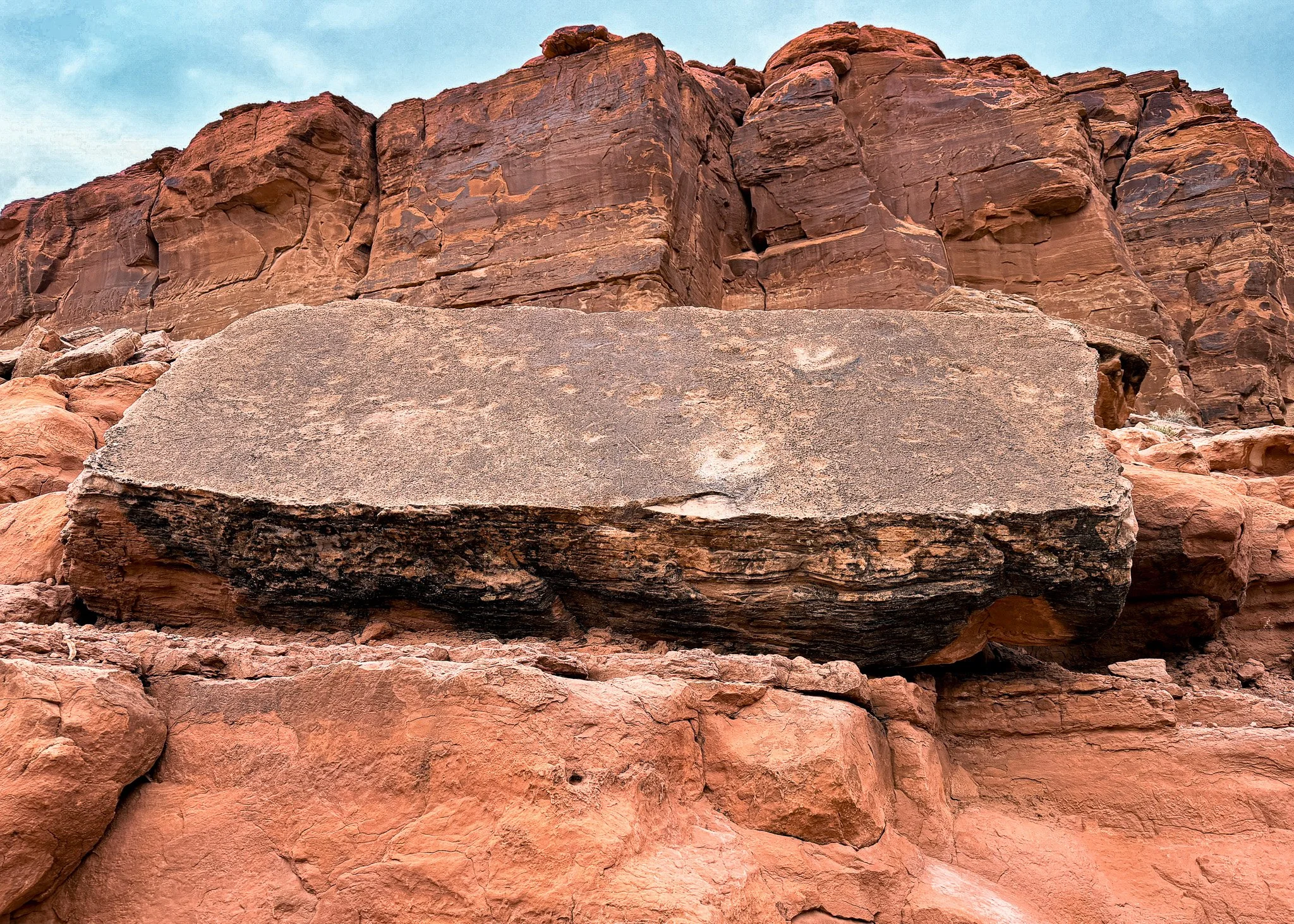 Large fallen sandstone slab at Poison Spider Trail near Moab, Utah, showing multiple three-toed theropod dinosaur tracks preserved in the Morrison Formation.