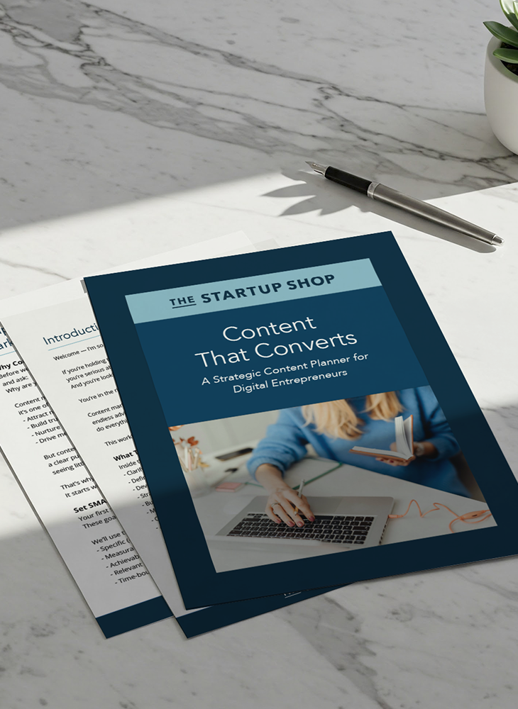 A few pages from the Startup Shop "Content that Converts" product, including the cover layer over some internal pages, sitting on a marble benchtop.