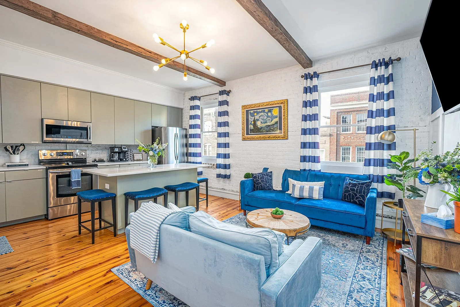 hosting savannah luxury vacation rental the blue belle blue sofas, green kitchen with broughton street views and cute decor