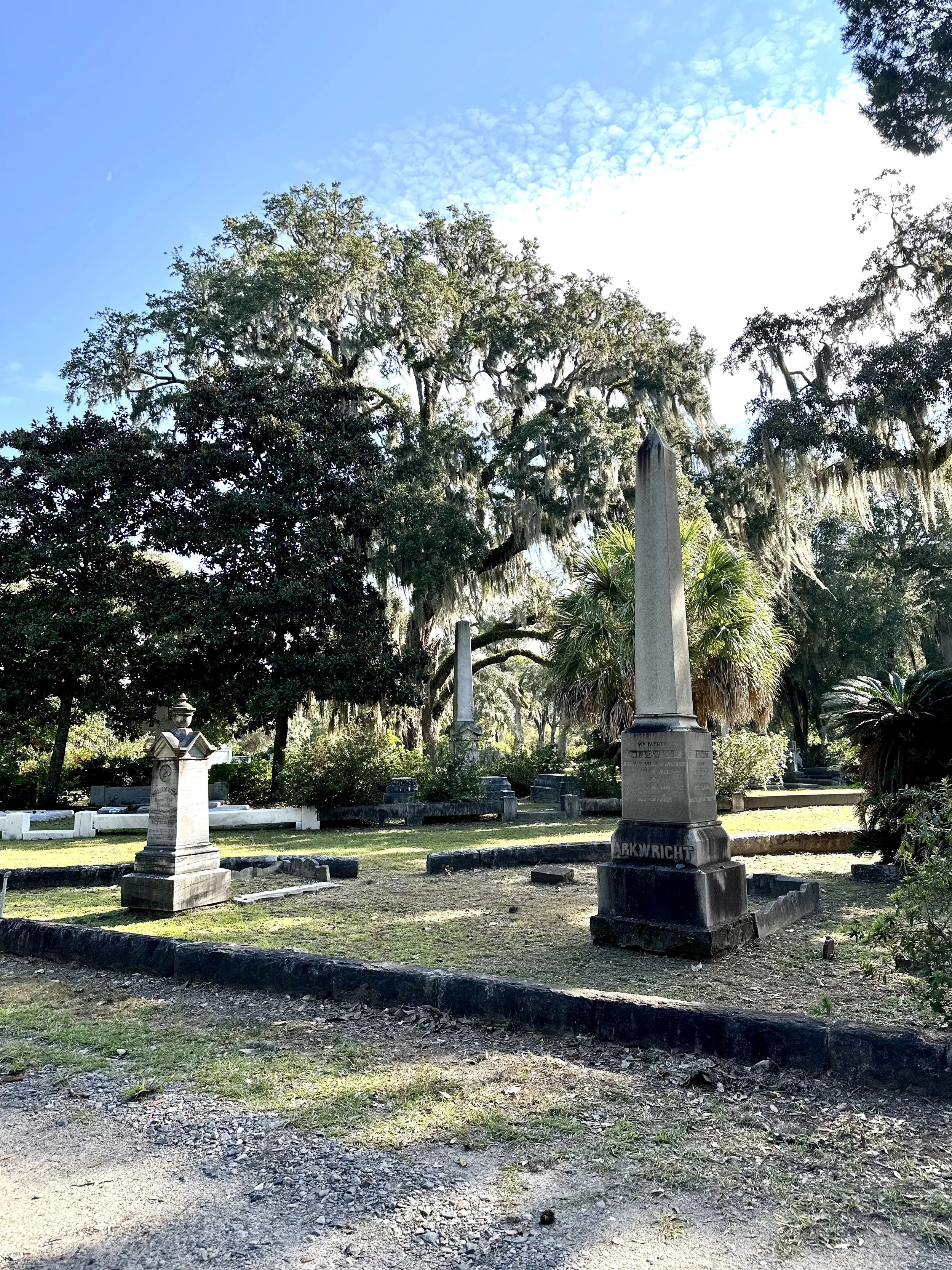 Historic stone obelisk monument surrounded by Spanish moss-covered live oak trees at Bonaventure Cemetery in Savannah, Georgia, showcasing the cemetery's beautiful Victorian memorials and peaceful landscape.