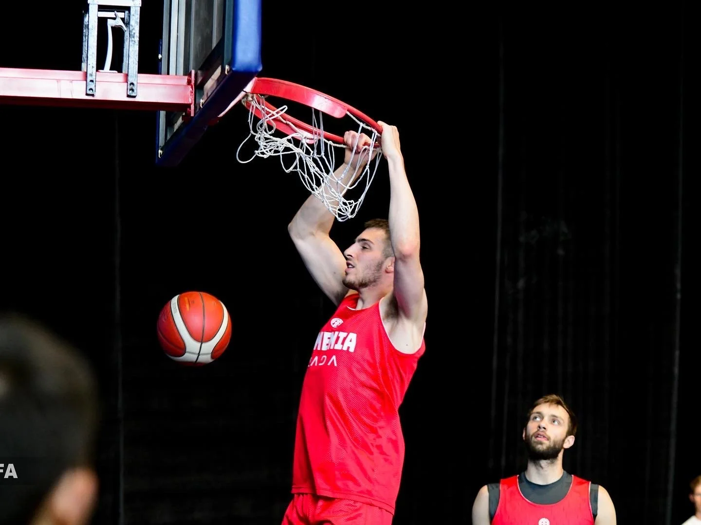 Basketball player in red jersey dunking a ball