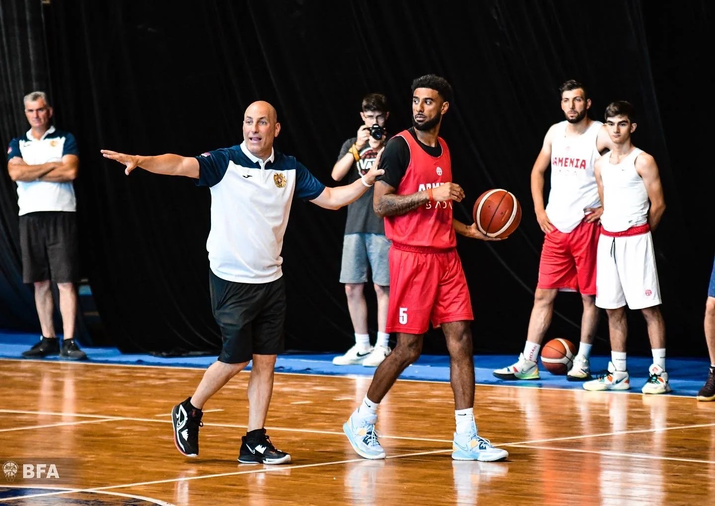 Basketball coach instructing players during practice