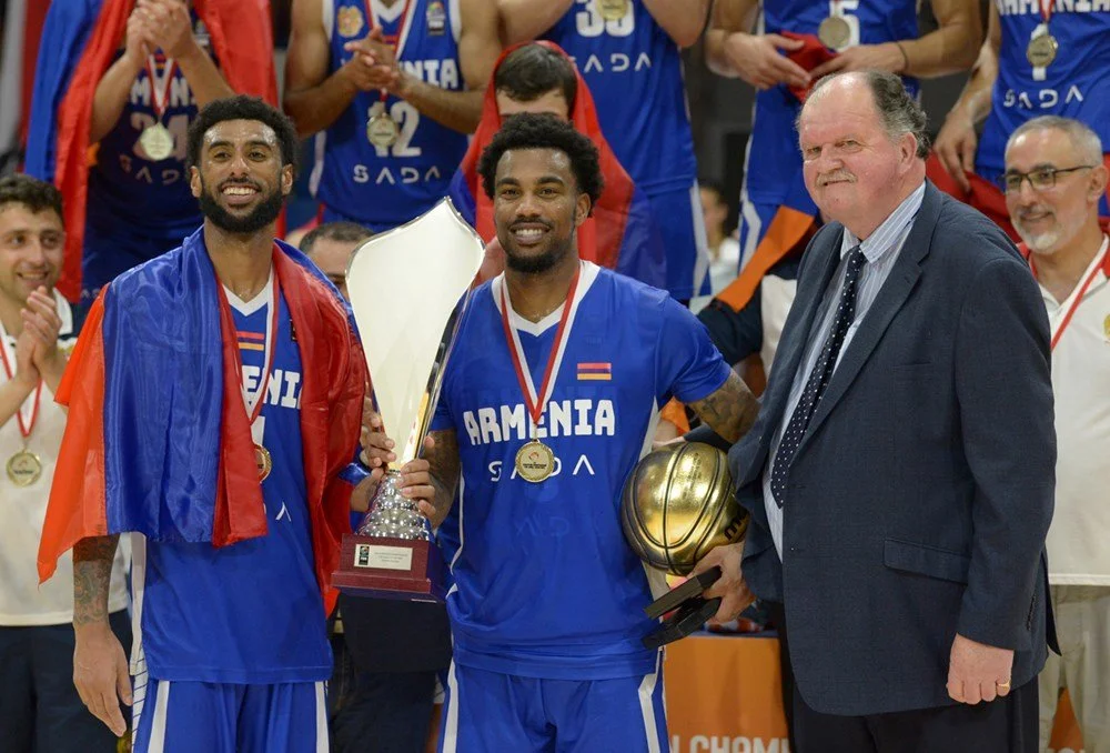 Basketball team celebrating with trophies