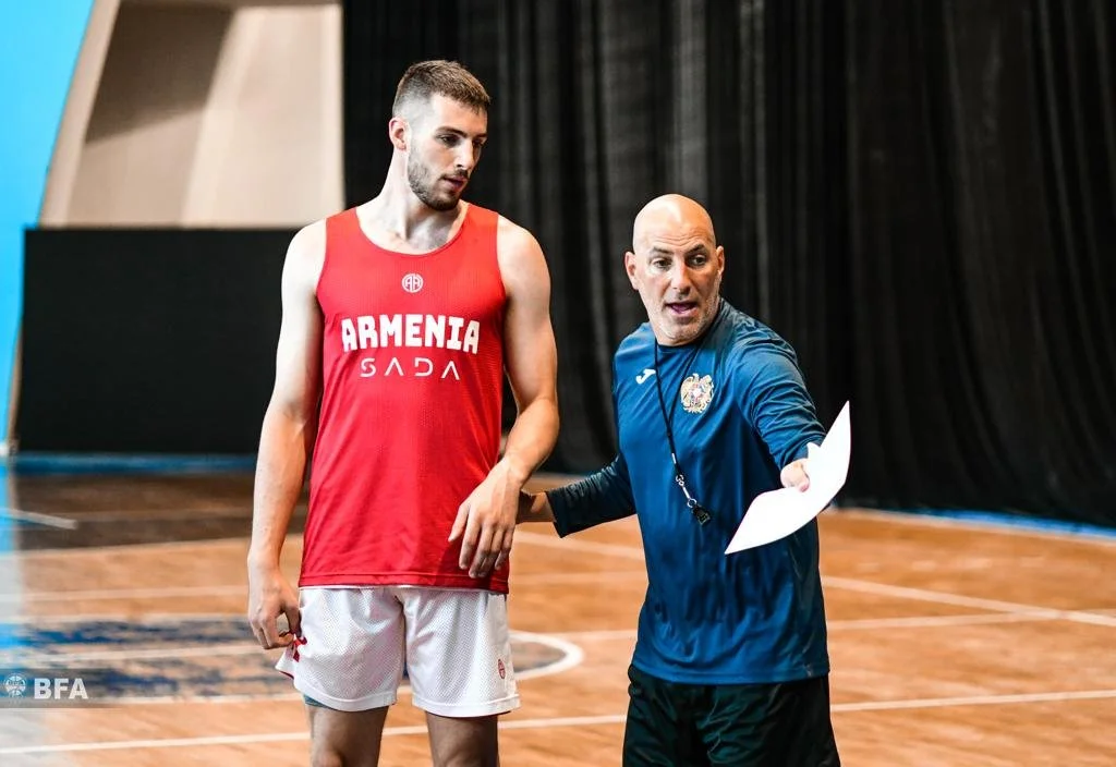 Coach giving instructions to basketball player on indoor court