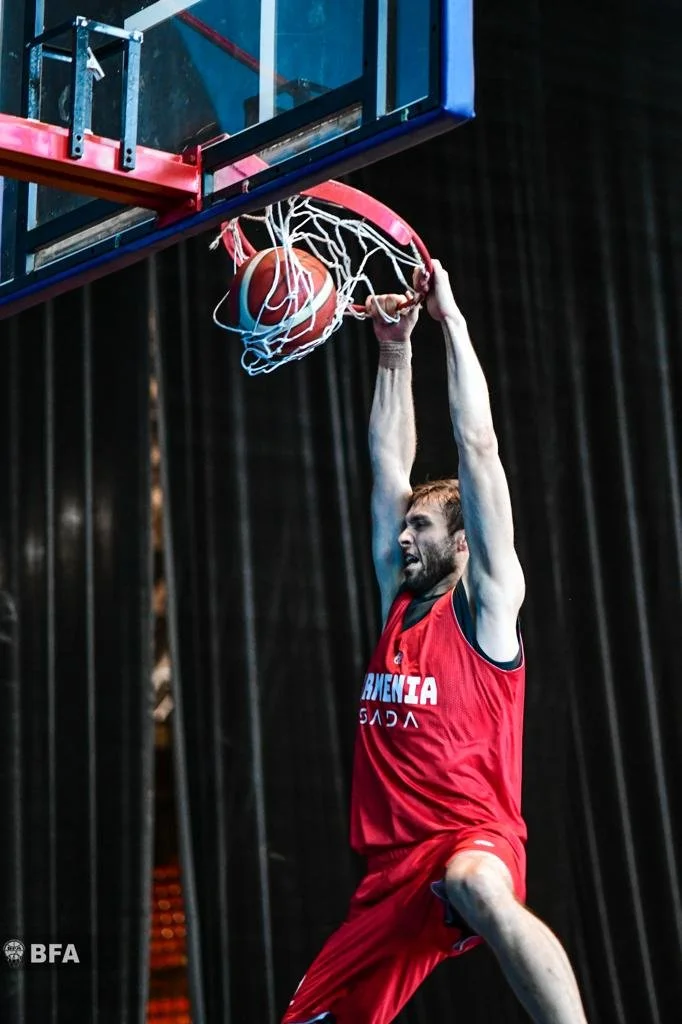 Basketball player in red jersey dunking ball