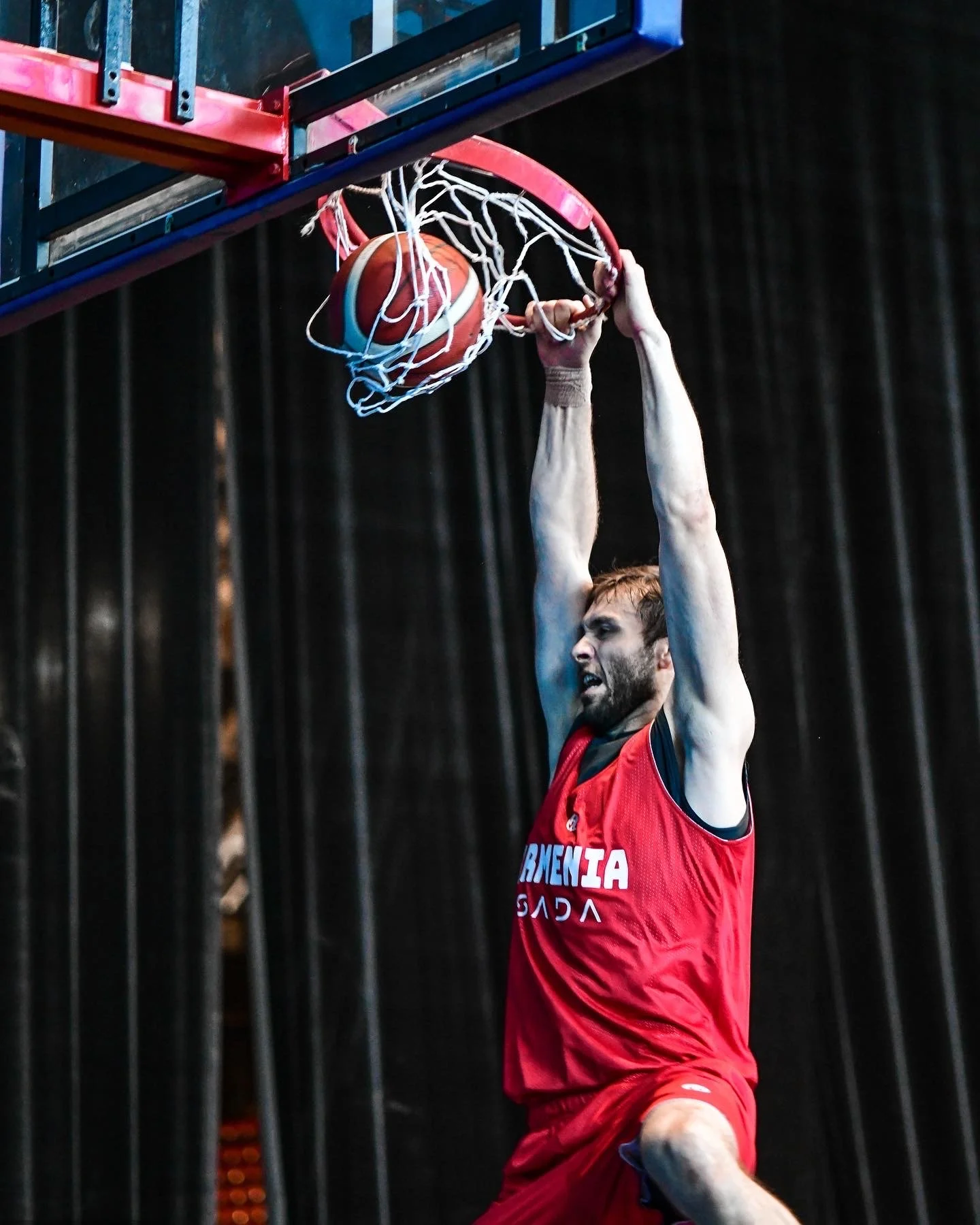 Basketball player in red jersey dunking a basketball