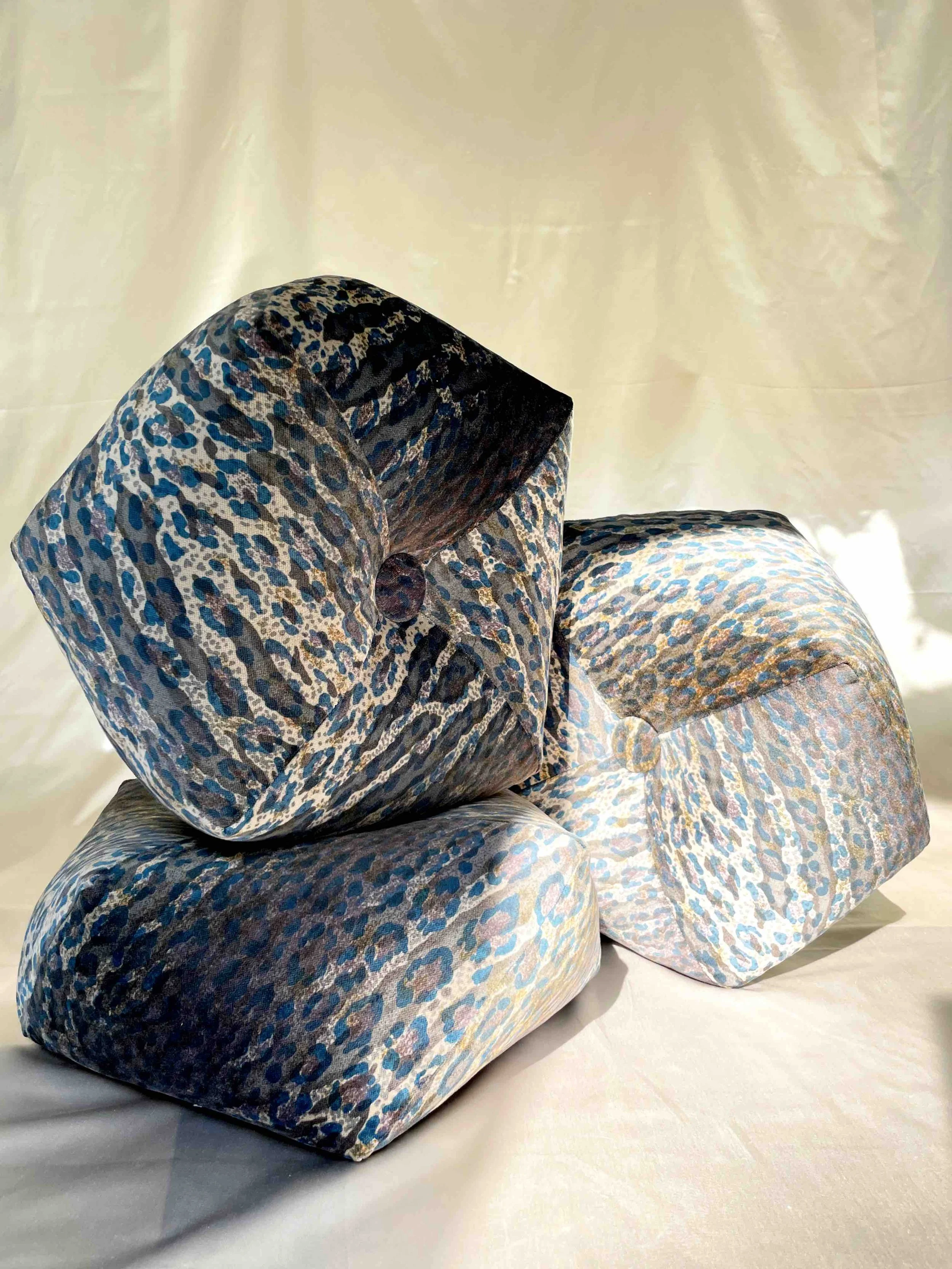 Three blue and grey leopard octagon pillows stacked against a light backdrop.