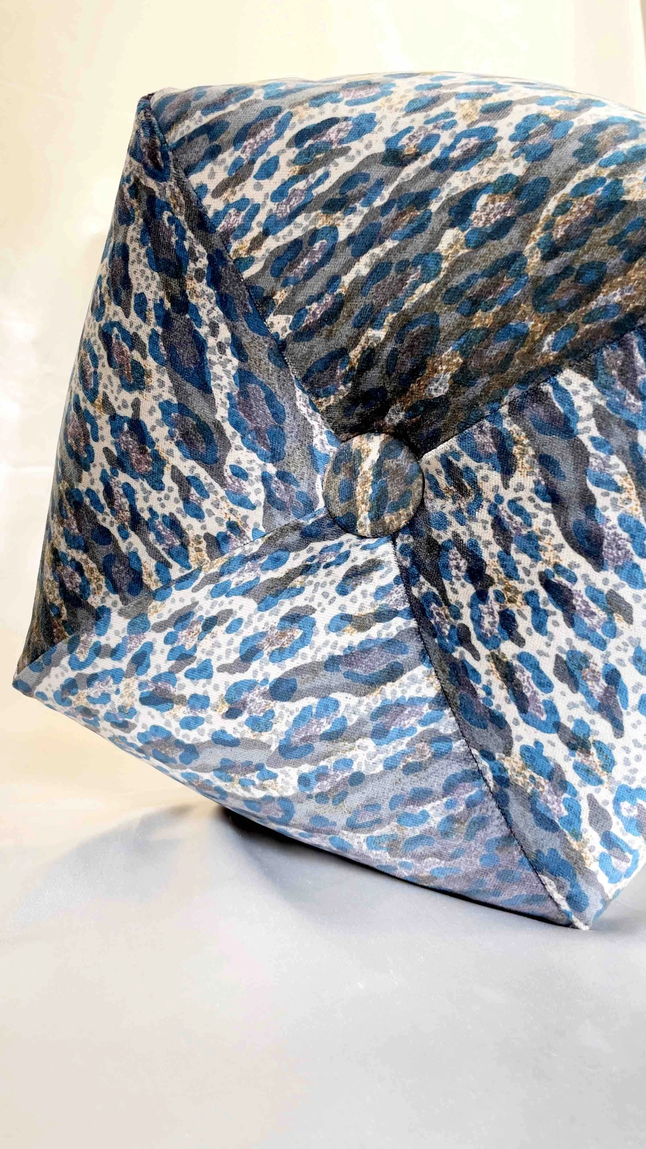 Close-up of blue and grey octagon pillow on a light background.