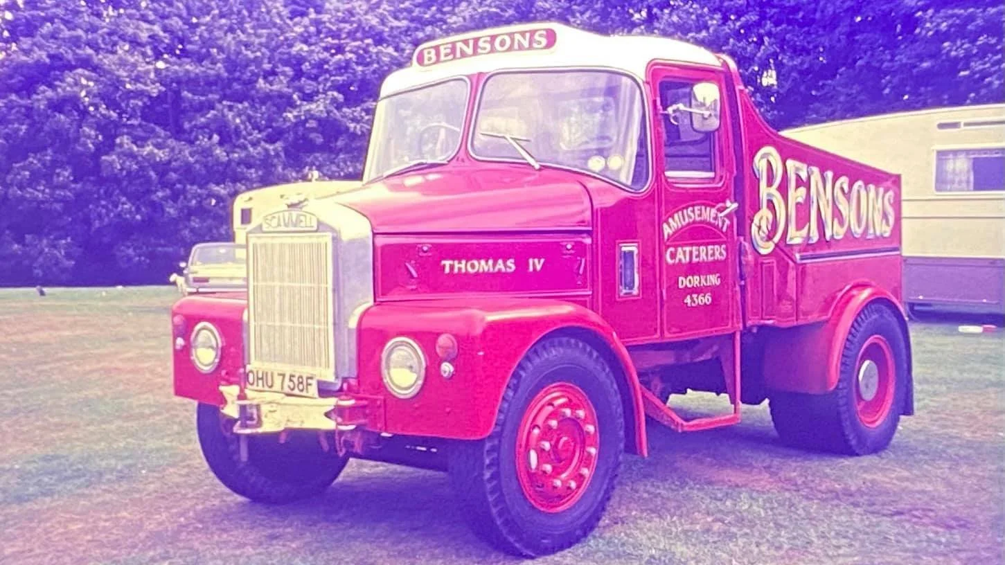 Vintage Scammell red truck with "Bensons" branding, parked on grass, with trees in the background.