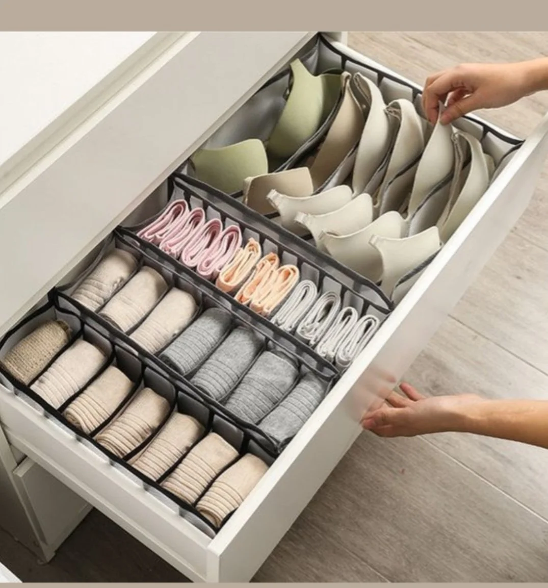 Open drawer with neatly organized bras, socks, and underwear in sections.