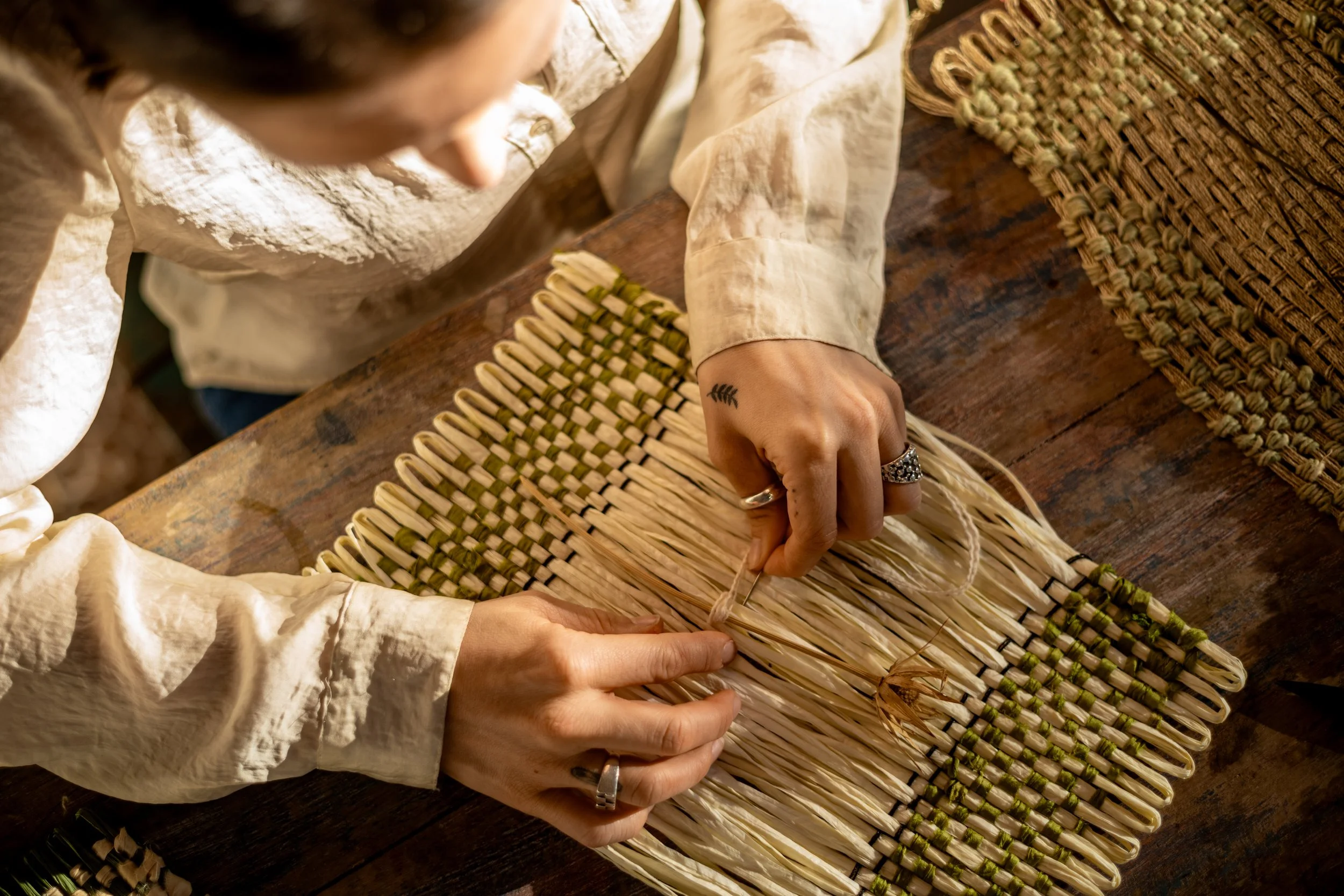 a young woman weaving with textiles