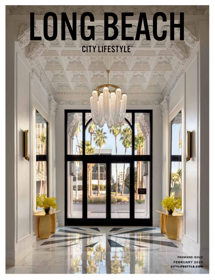 Elegant hotel lobby entrance of long beach ca historical condo building villa riviera with large glass doors, palm trees visible outside, and a chandelier hanging from the decorated ceiling in magazine founded by morehouse crafted interiors.