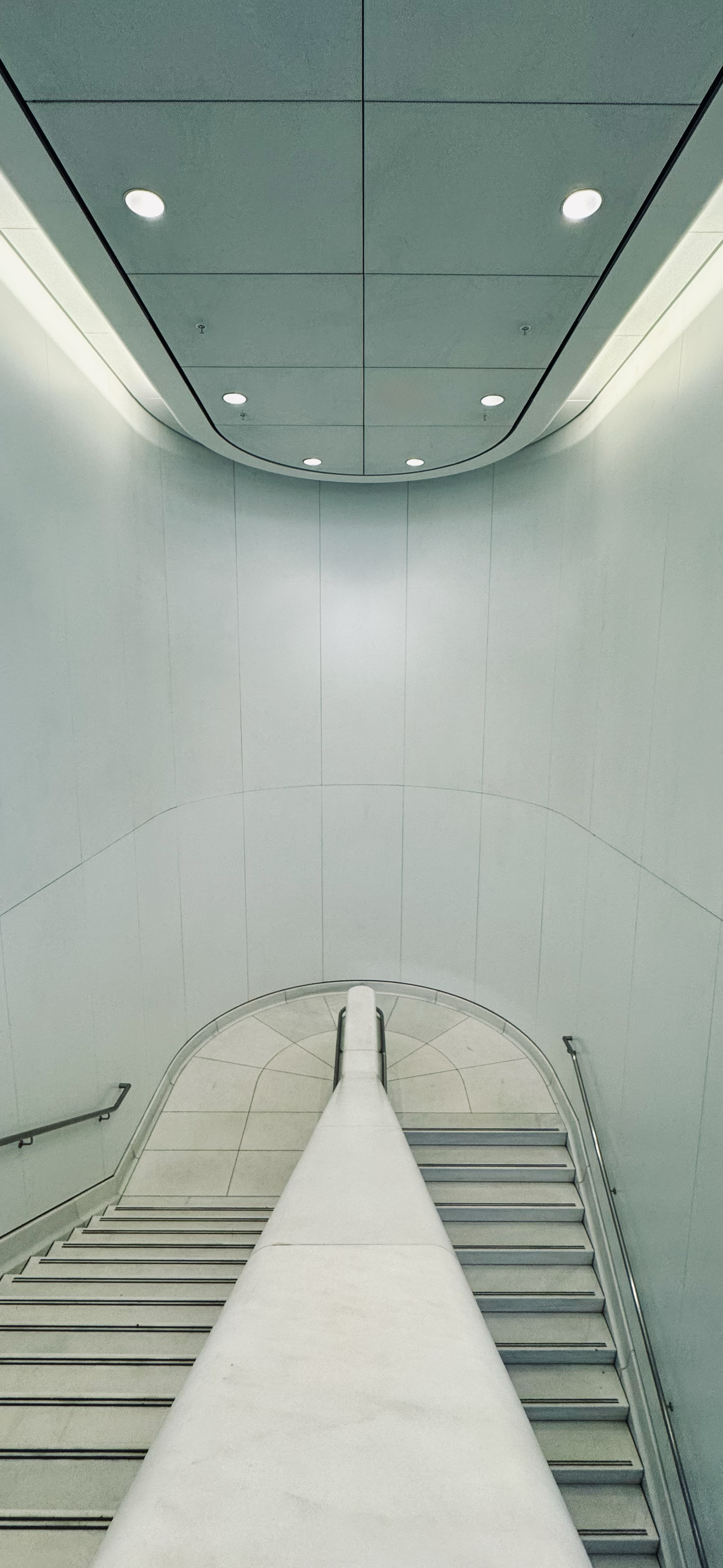 Minimalist interior staircase in the World Trade Center featuring clean lines, curved walls, and modern architectural design in New York City