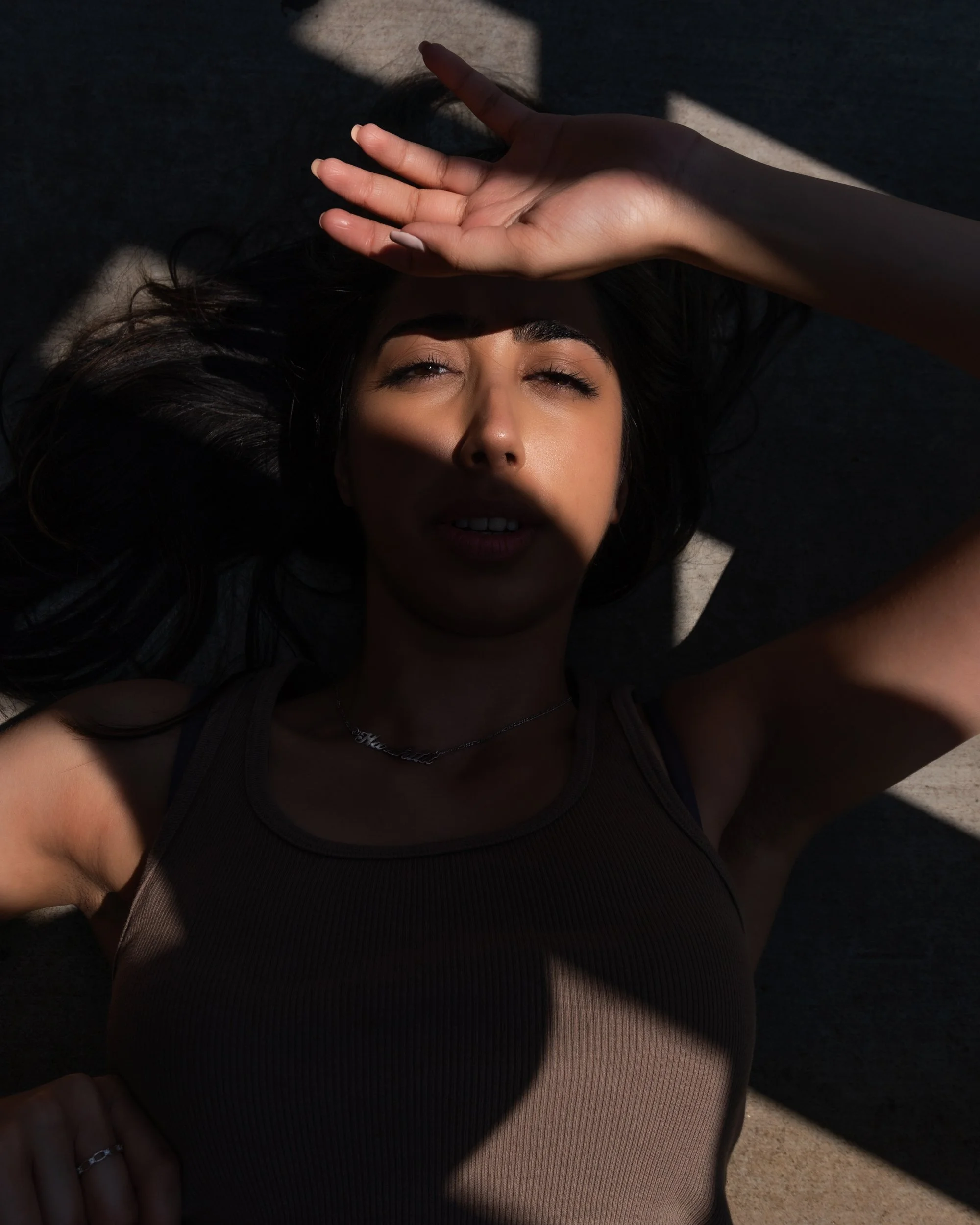 Close-up editorial portrait of Harshita with dramatic hard light and shadows across her face outdoors