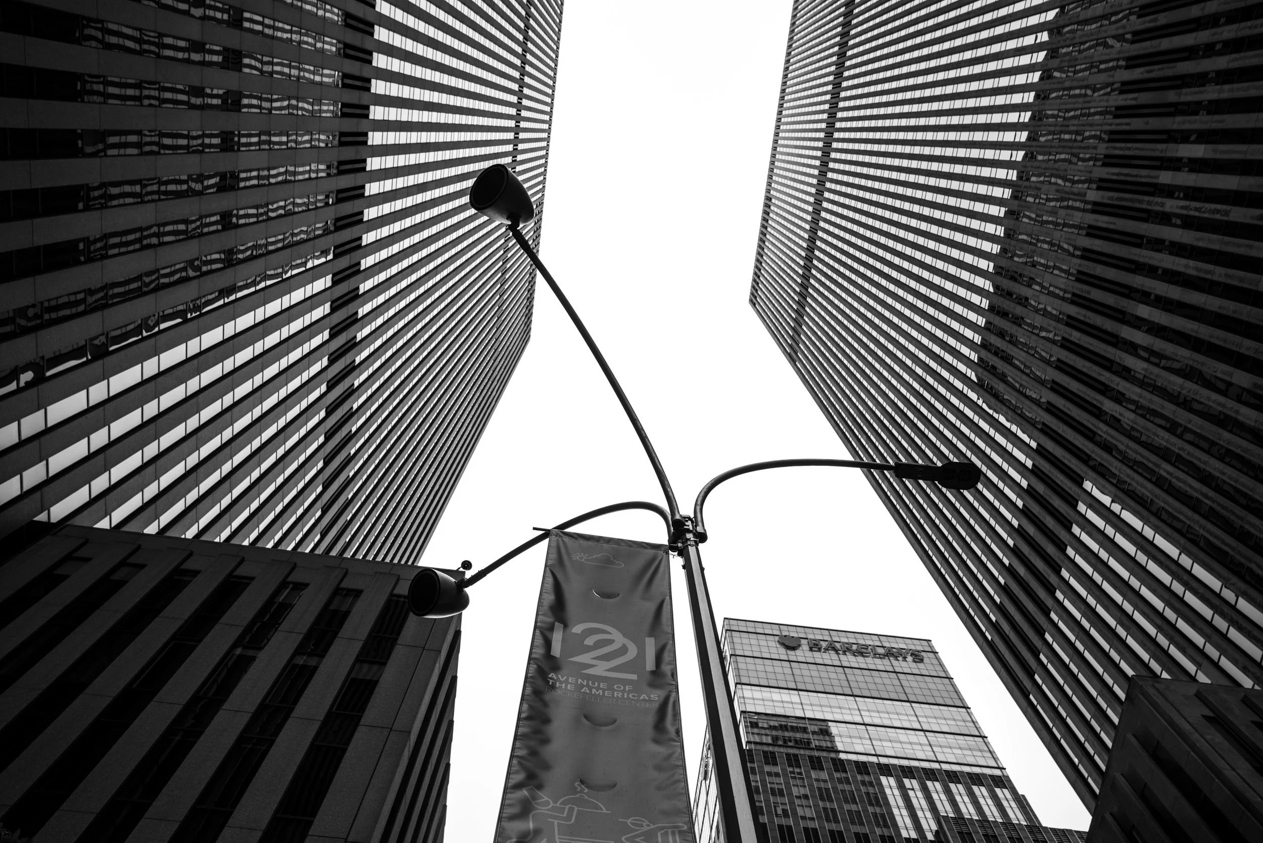Modern corporate office buildings in Manhattan photographed from a low angle, featuring glass facades and strong vertical lines in New York City