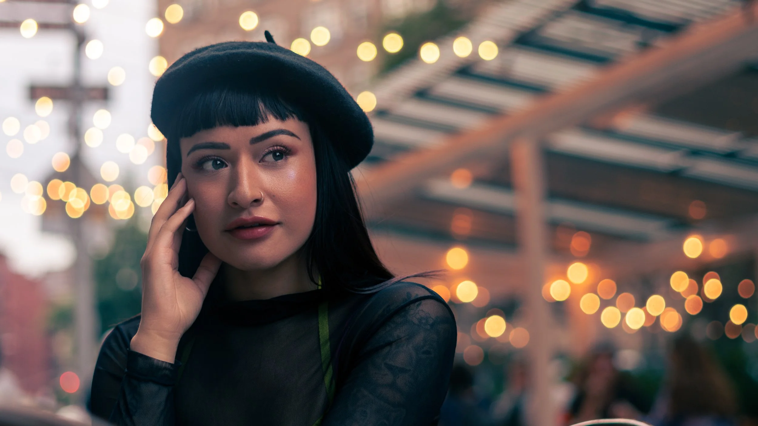 Editorial portrait of Daniela in natural light with soft expression outside a cafe in New York City