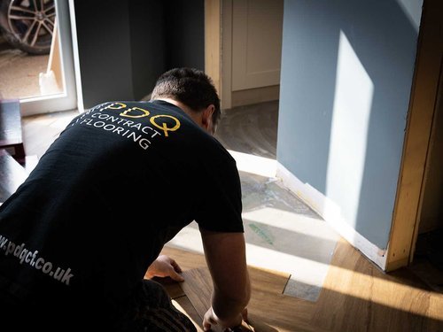 A PDQ Fitter laying a floor - Photography Yoke creative Agency