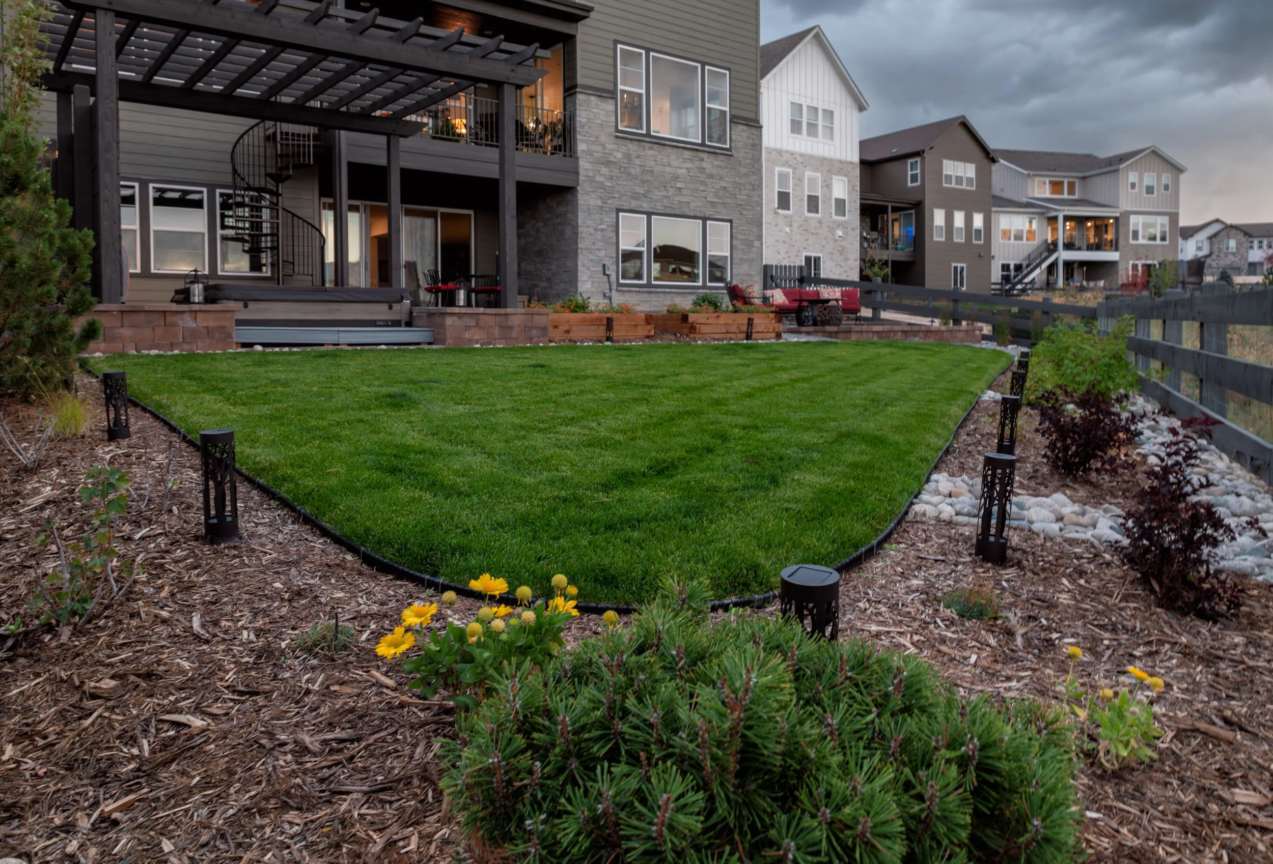 Finished Centennial Colorado backyard with professionally planned softscape design, defined lawn, mulch beds, and seasonal plantings