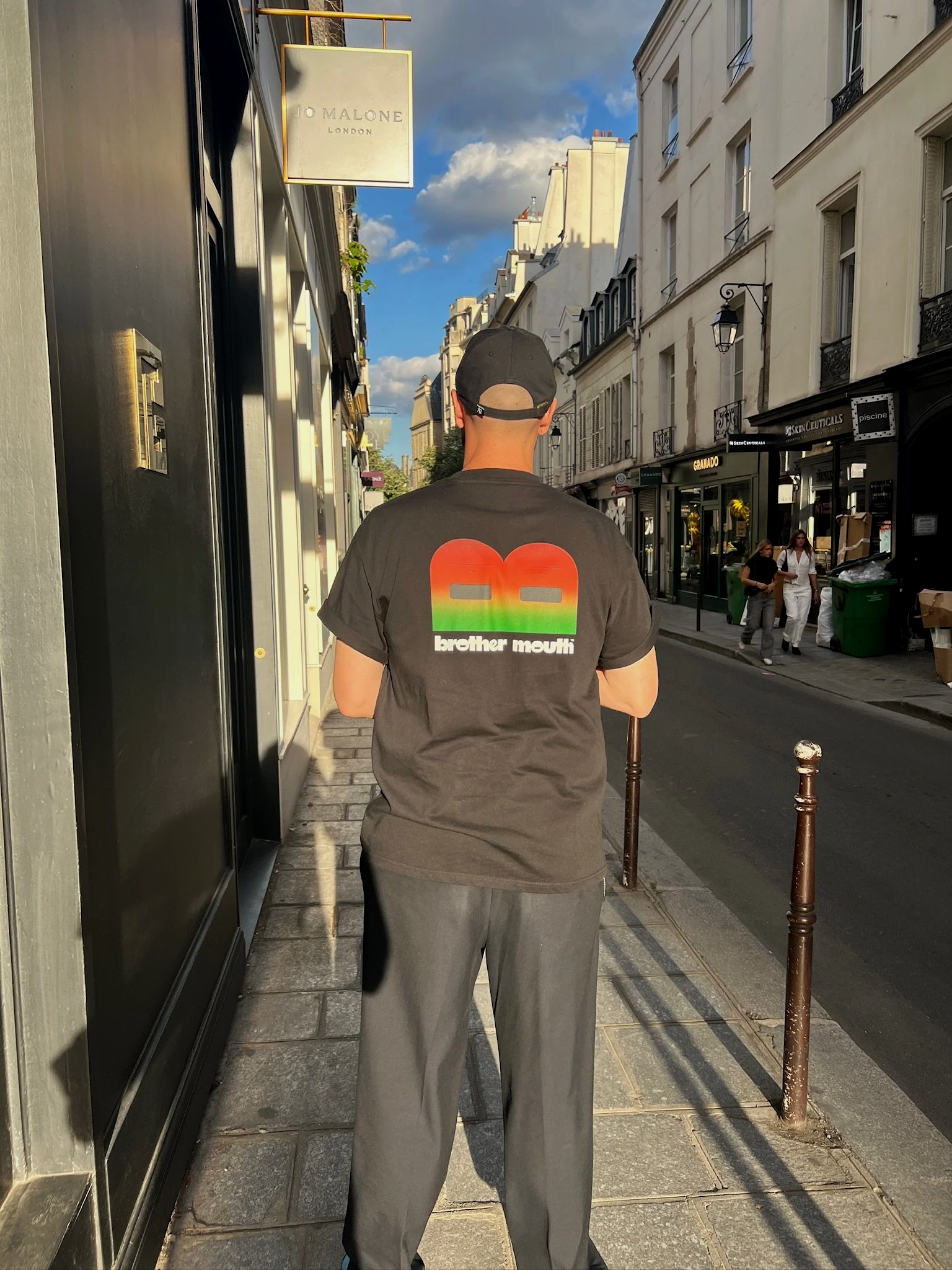 Brother Mouth street scene featuring a person walking through a city wearing a Brother Mouth graphic on their back.
