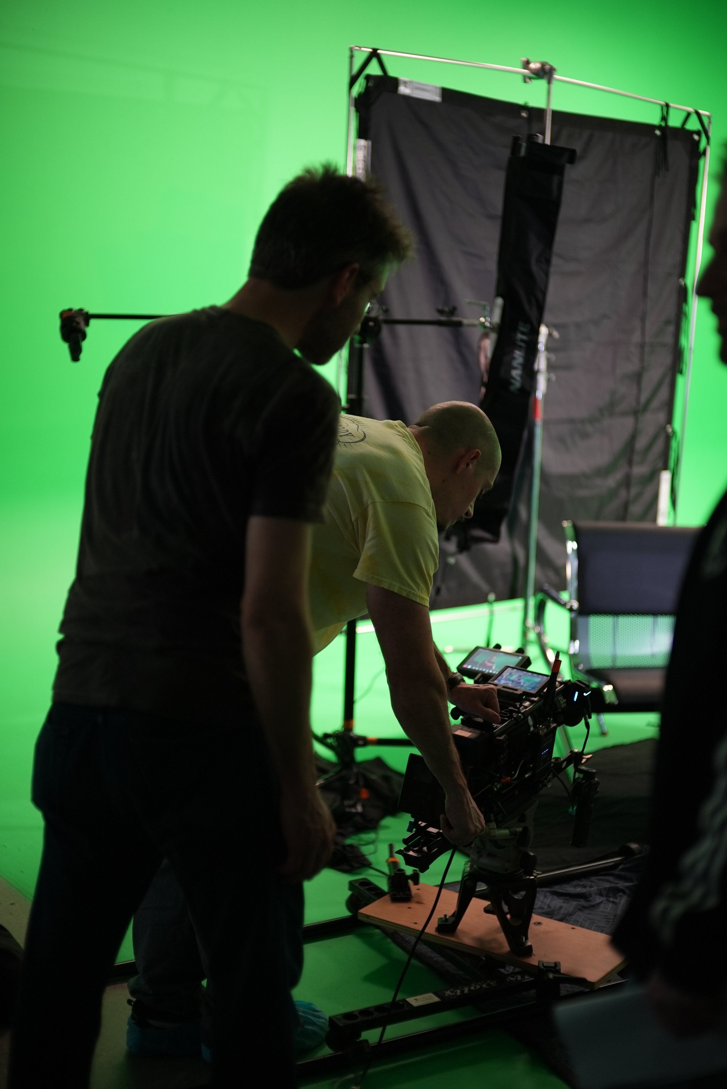 Behind-the-scenes production setup for a Brother Mouth Neck Pillow shoot using a green screen and professional camera equipment.