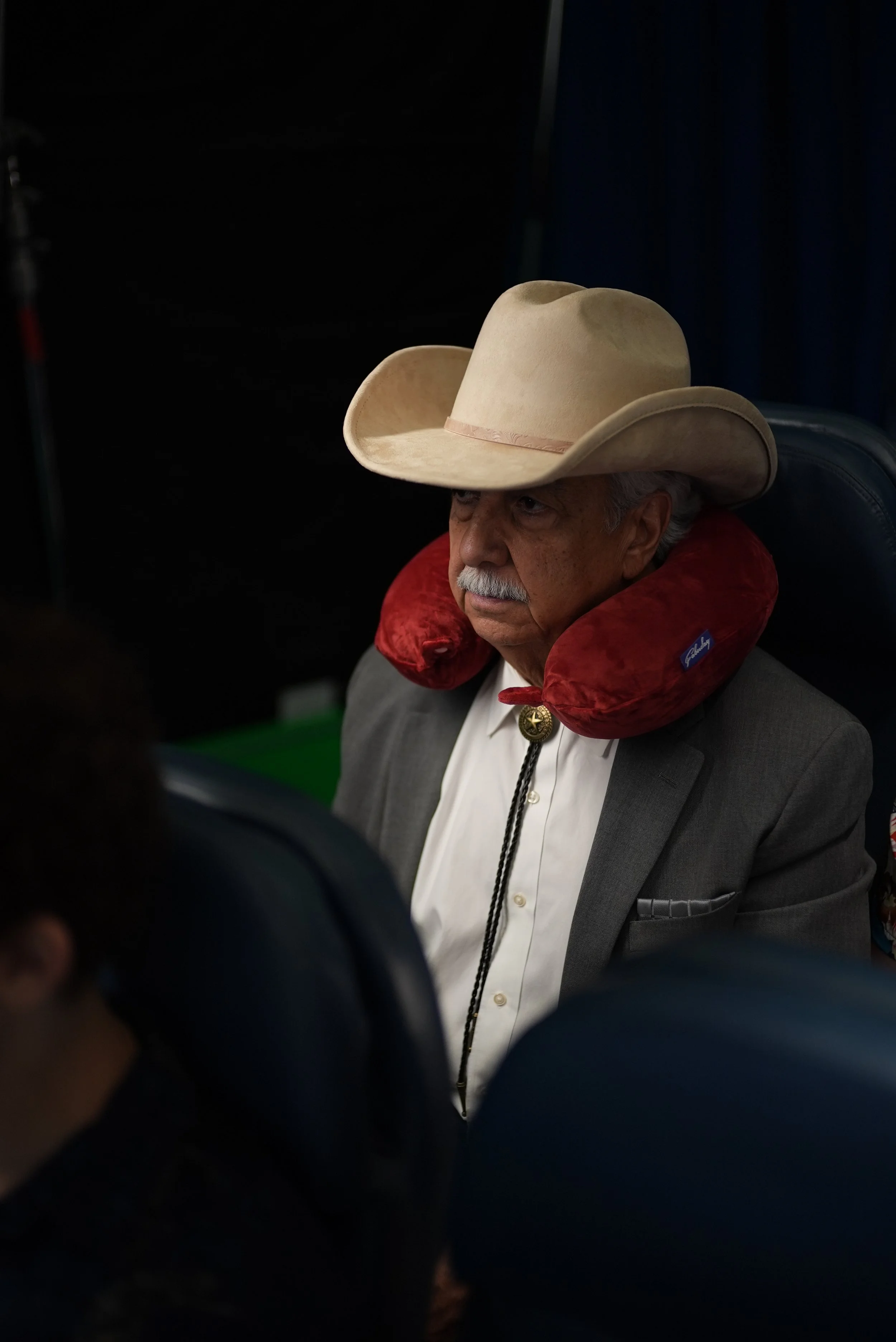 Character from Brother Mouth’s Neck Pillow project wearing a cowboy hat, suit, and red neck pillow.
